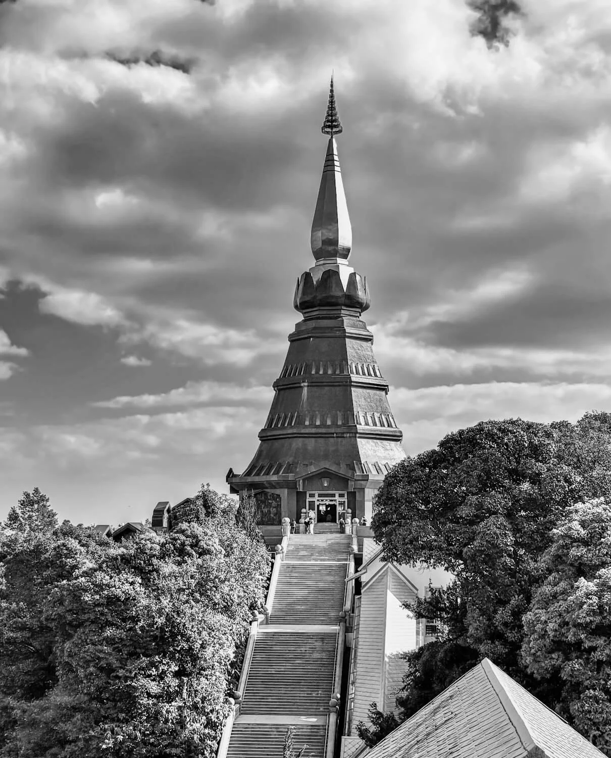 Black-and-white photo of Phra Mahathat Chedi Nophamethanidol (the King's Chedi), Doi Inthanon National Park, Thailand, framed by trees.