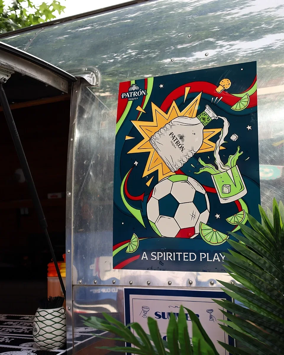Colorful poster with a soccer ball, a Patron tequila bottle, and a cocktail glass, with lime slices and chips, advertising a spirited play.