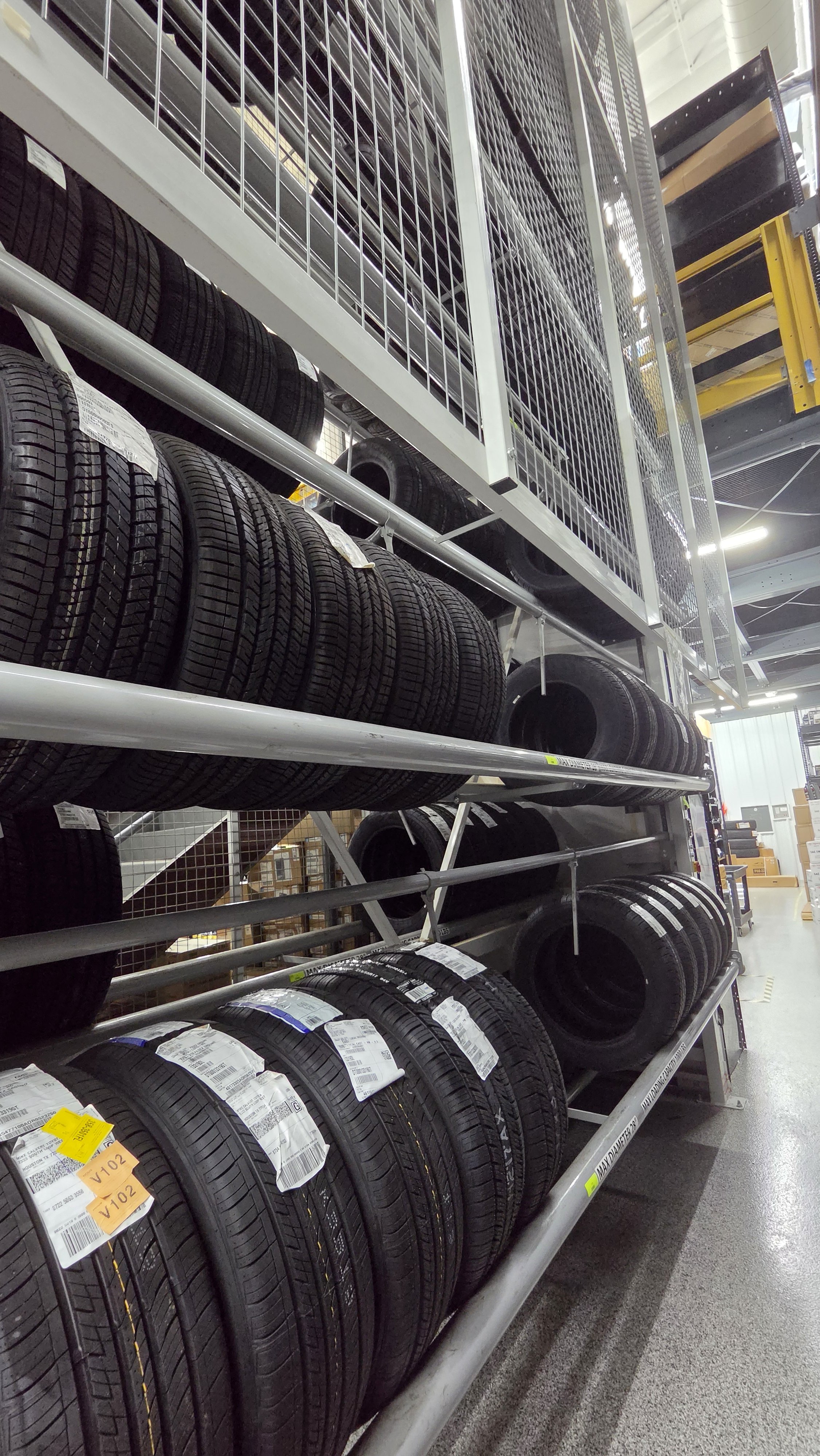 Display of car tires on metal shelves in a warehouse store.