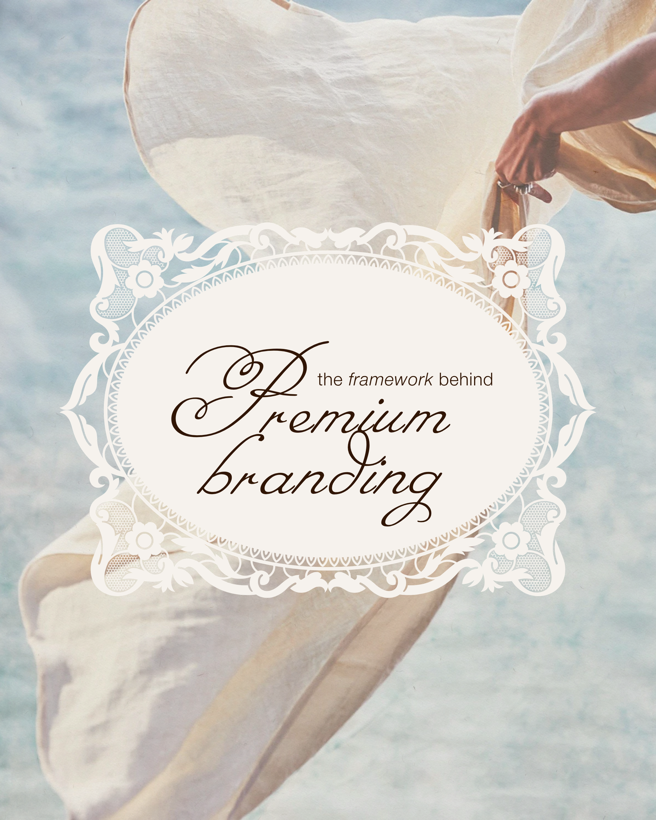 Close-up of a white paper wedding invitation with decorative floral border and elegant cursive text, held by a person's hand against a soft blue background.