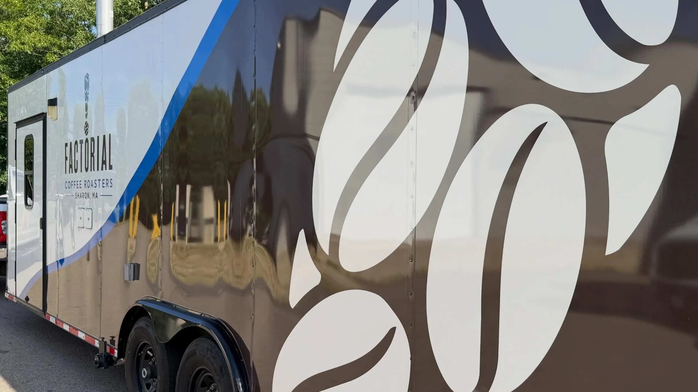 A large food truck with a shiny surface, displaying branding for Factoryial Coffee Roasters in Sharon, Massachusetts.