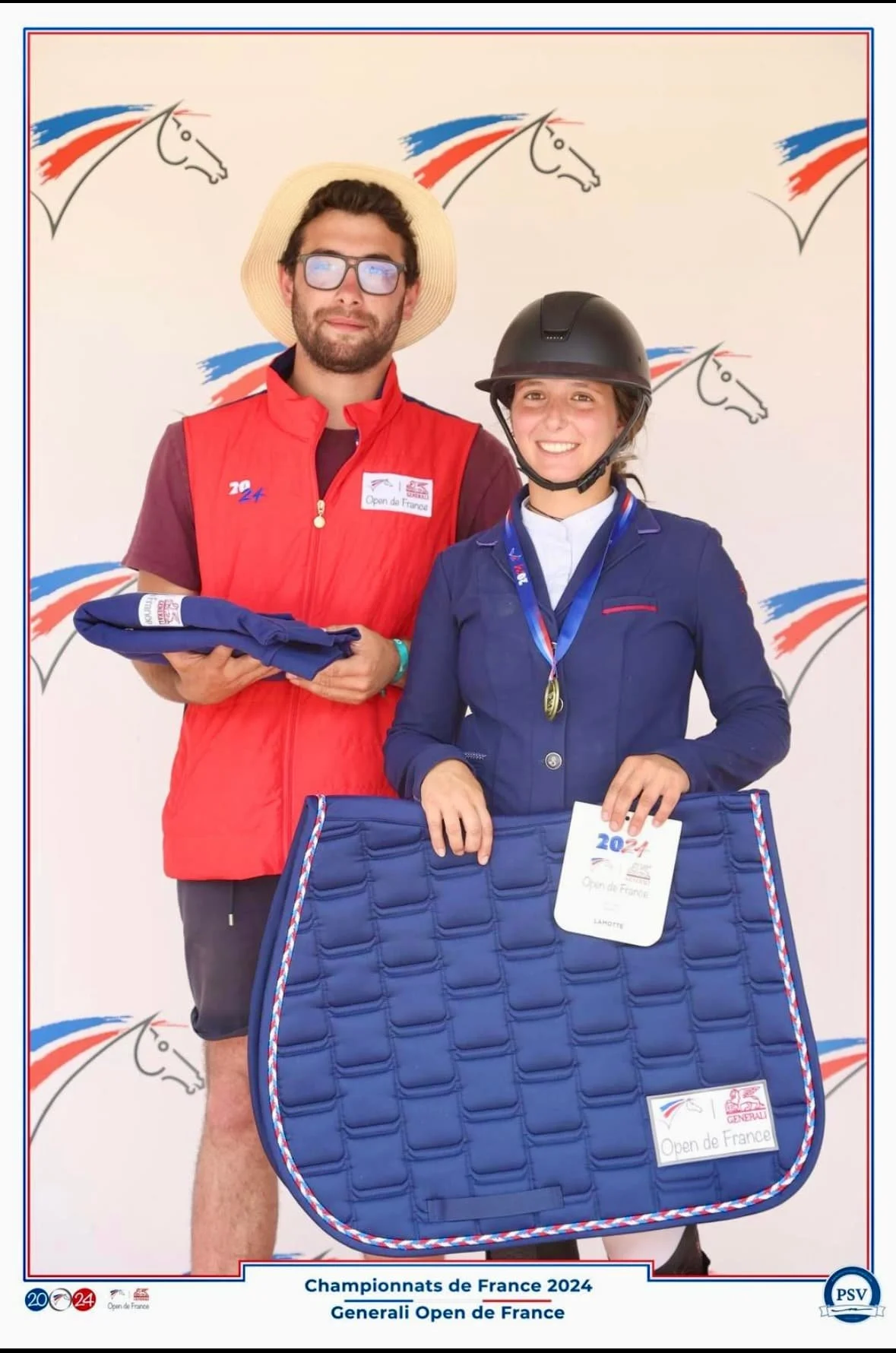 Deux jeunes cavaliers posent après une compétition, portant des médailles et des vestes aux couleurs de la France, avec un fond arborant des motifs de chevaux stylisés en rouge, blanc, et bleu, symbolisant la France.