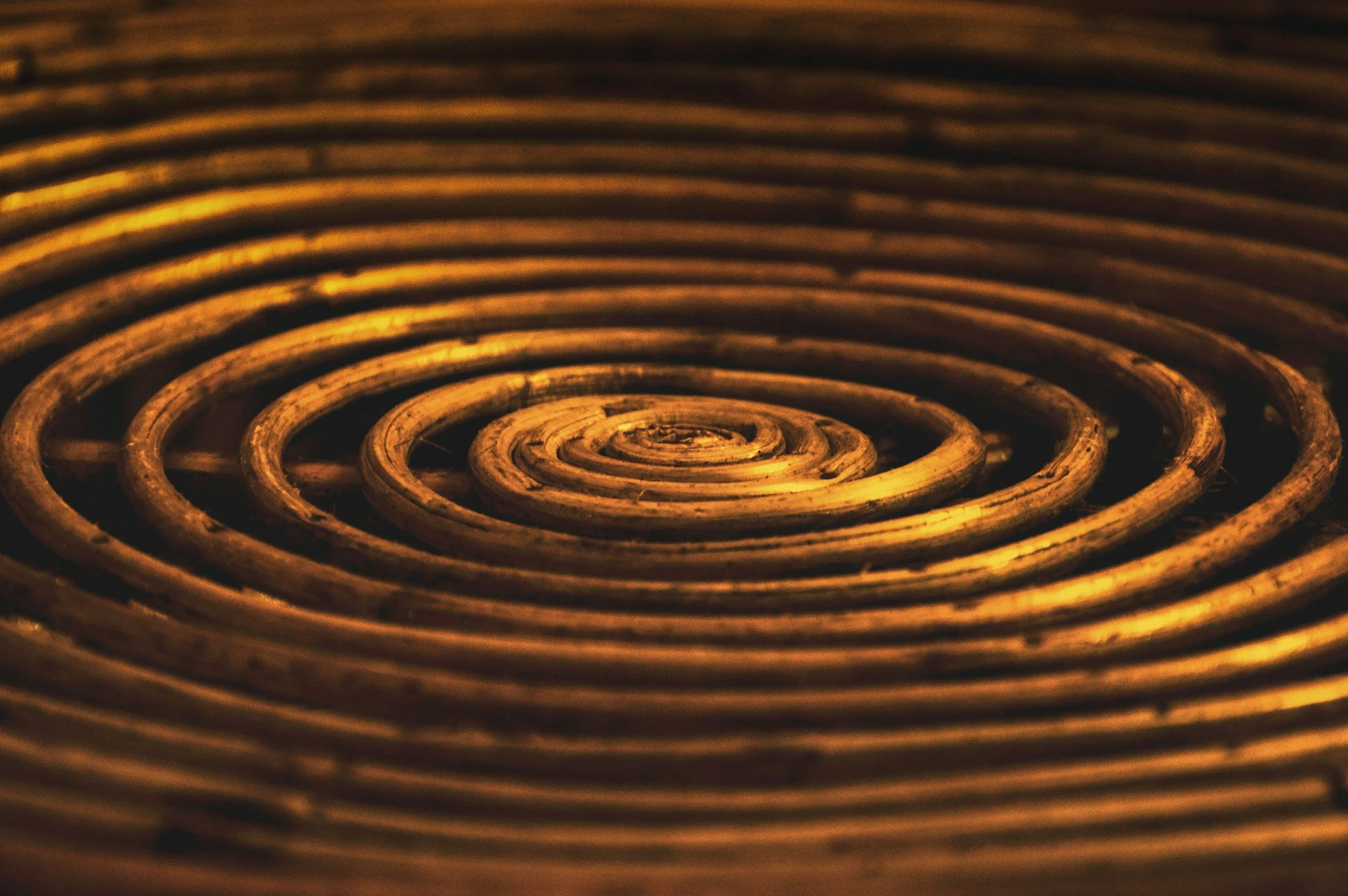 Close-up photograph of a coiled heating element with a metallic, rusty appearance.