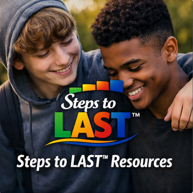 Two teenage boys smiling and embracing outdoors.