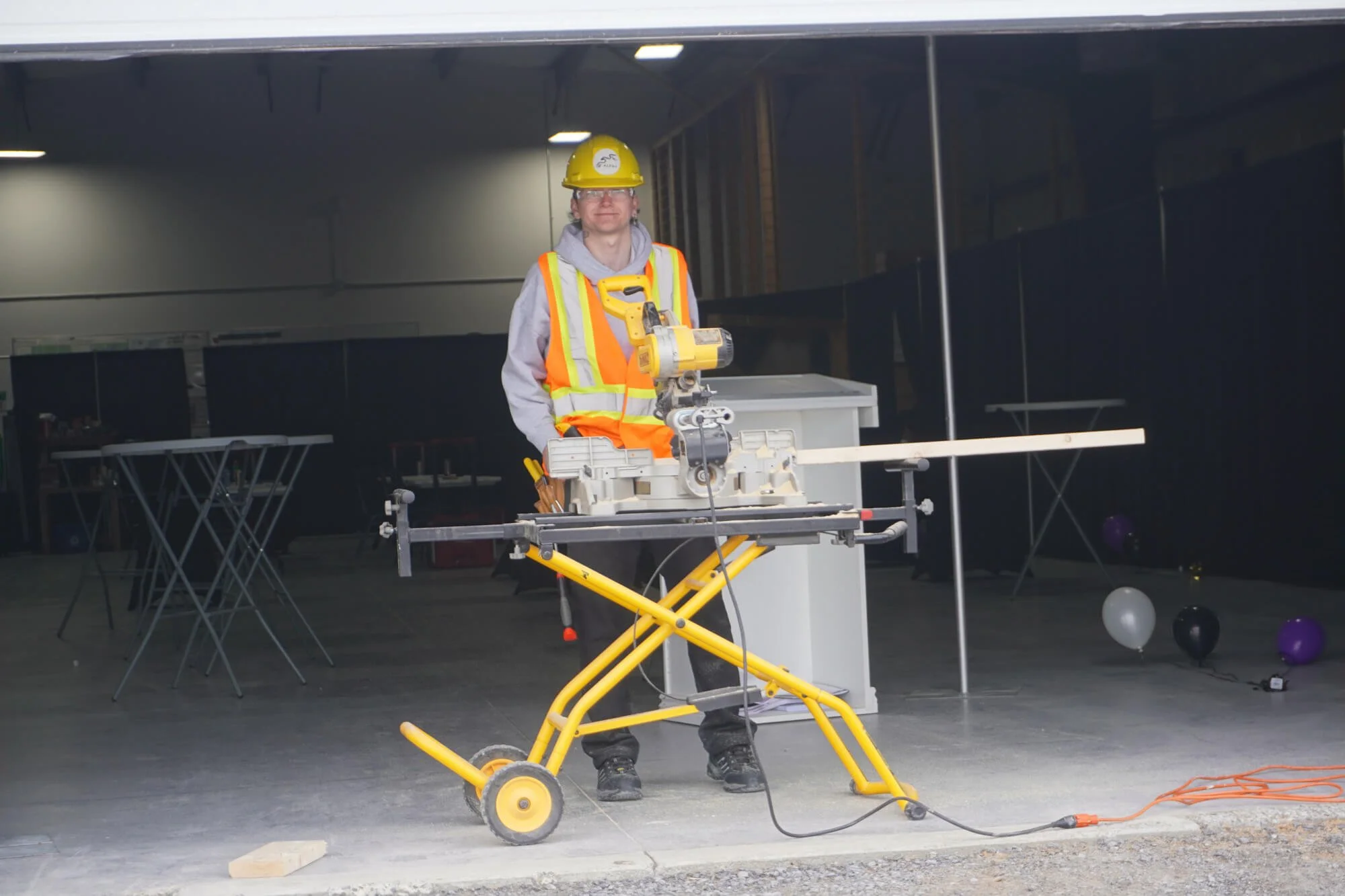Indigenous trainee in safety gear operating a saw during an ALFDC construction and skilled trades pre-apprenticeship program.
