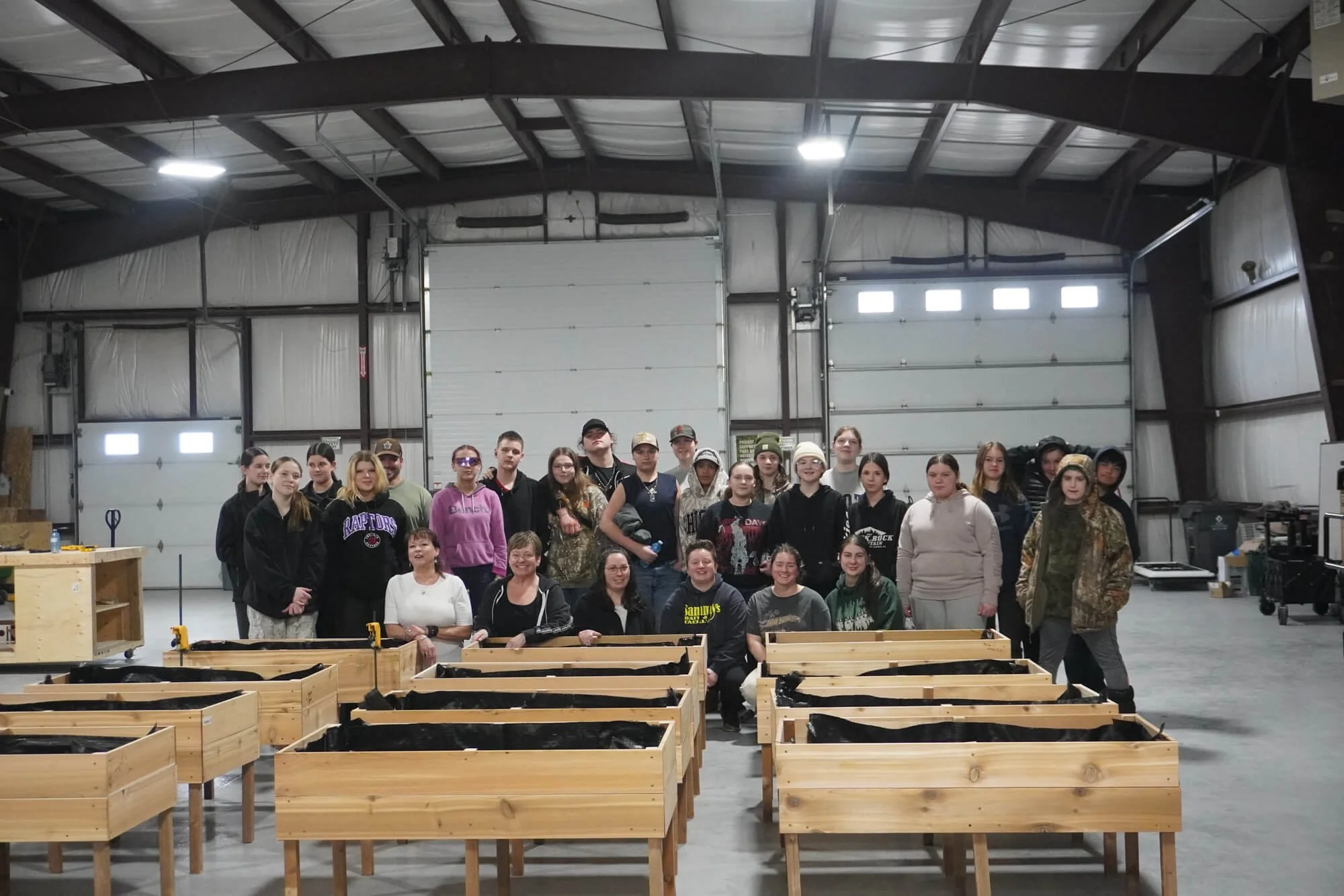 Group of Indigenous community members gathered in a large industrial workshop for an ALFDC training and skills development event.