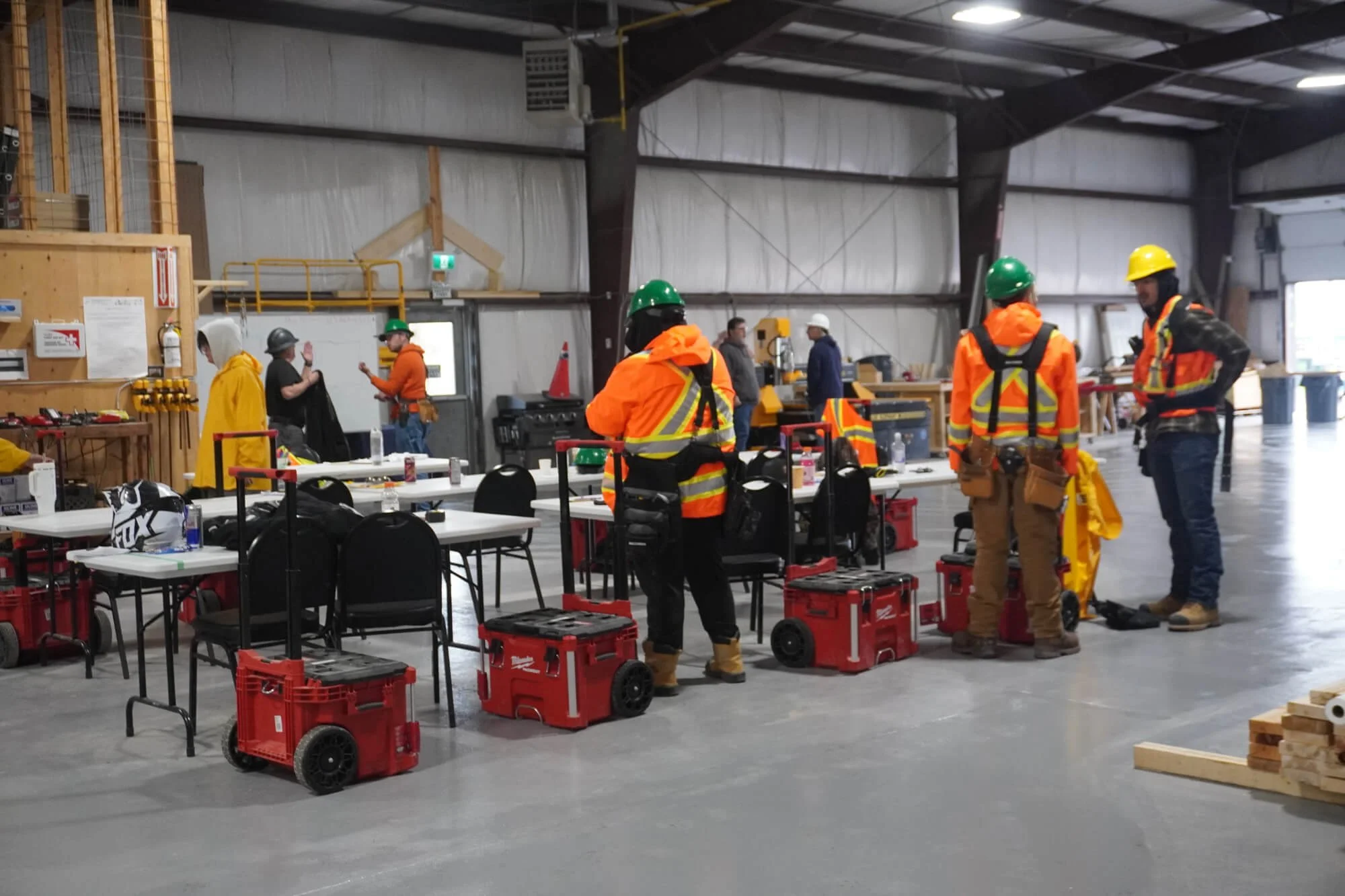 Indigenous community members participating in an ALFDC skilled trades workshop, exploring a table of tools.