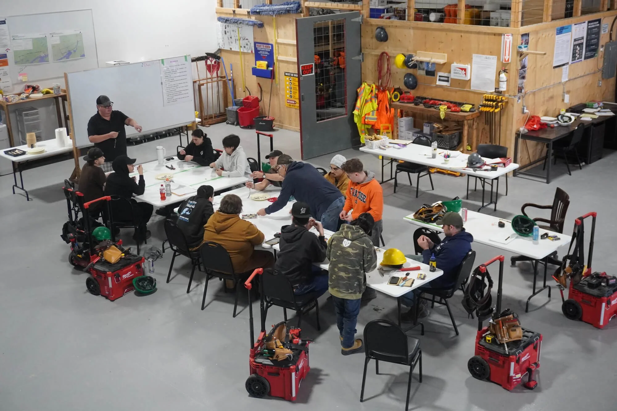 Community members participating in a ALFDC skilled trades workshop, discussing and reviewing educational materials.