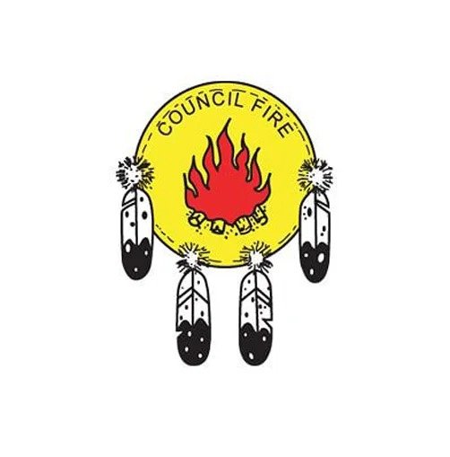 Emblem of the Council Fire with a yellow circle, a red flame symbol in the center, and five black and white feathers hanging around it.