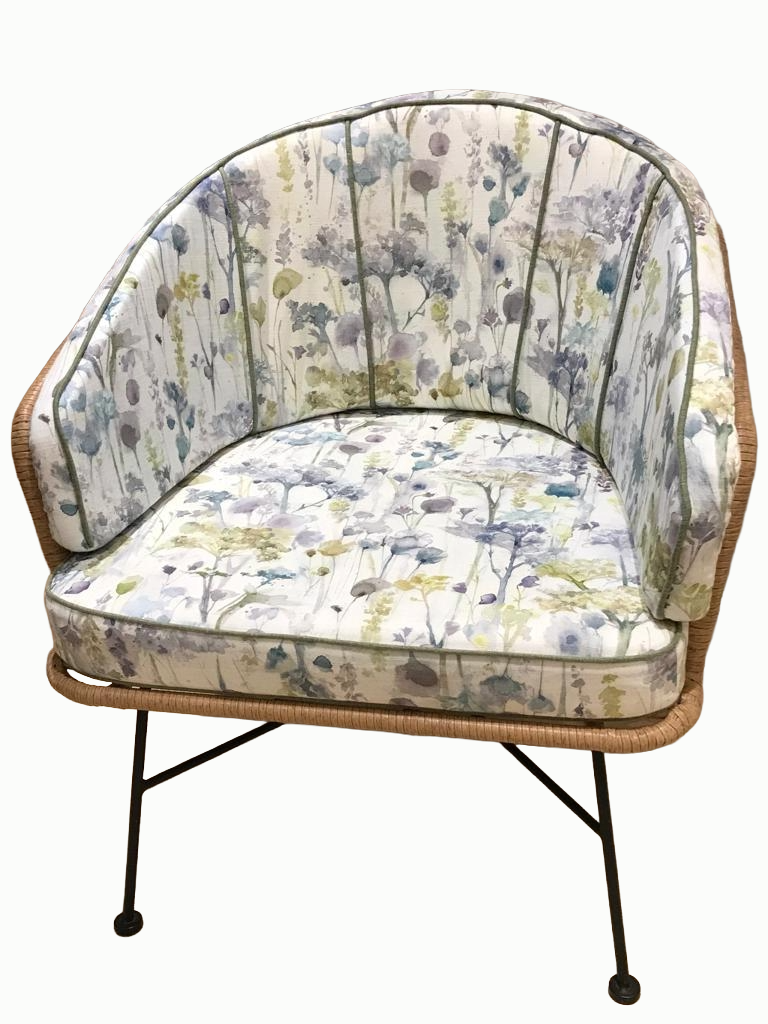 A vintage-style armchair with floral upholstery and metal hairpin legs.