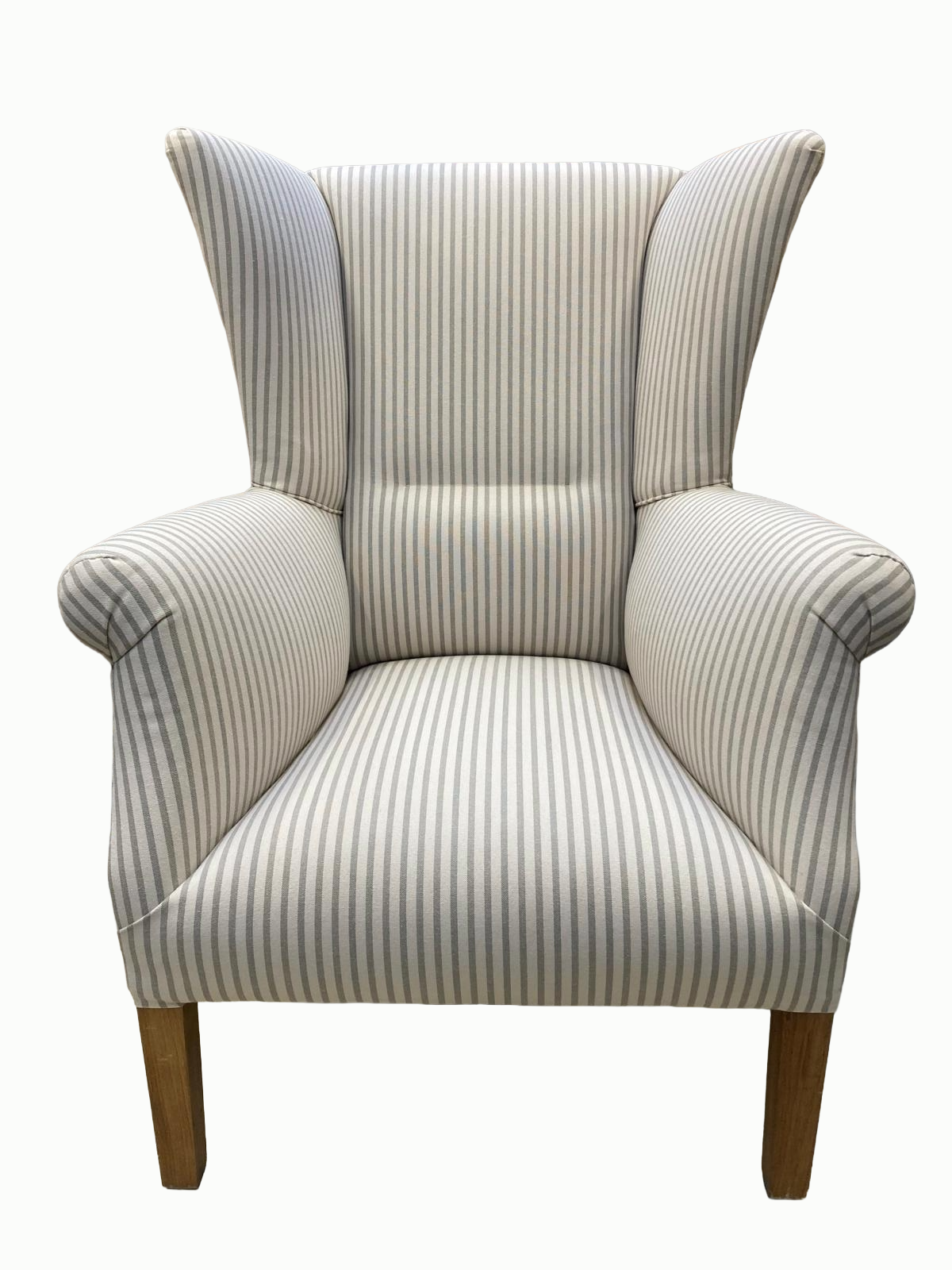 A high back armchair with beige and white striped upholstery and wooden legs.