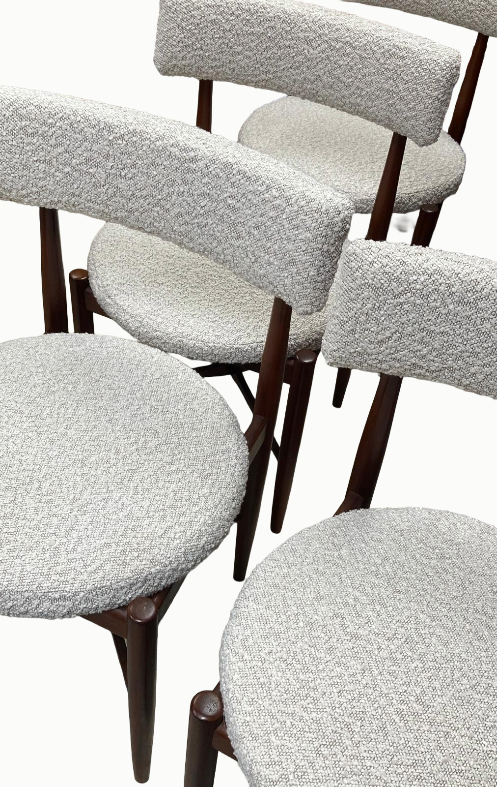 A group of mid-century modern chairs with wooden frames and textured fabric cushions and backrests.