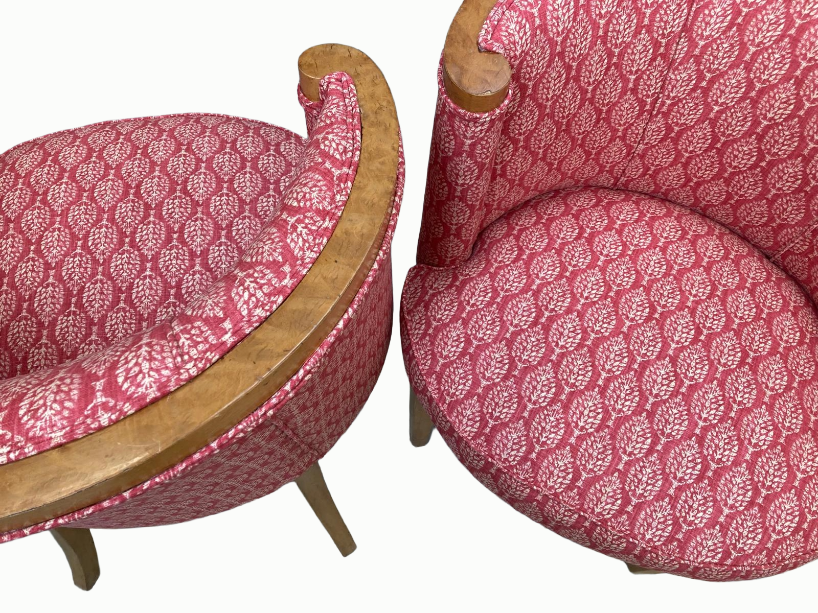 Two vintage chairs with pink and white patterned upholstery and wooden frames, positioned side by side.