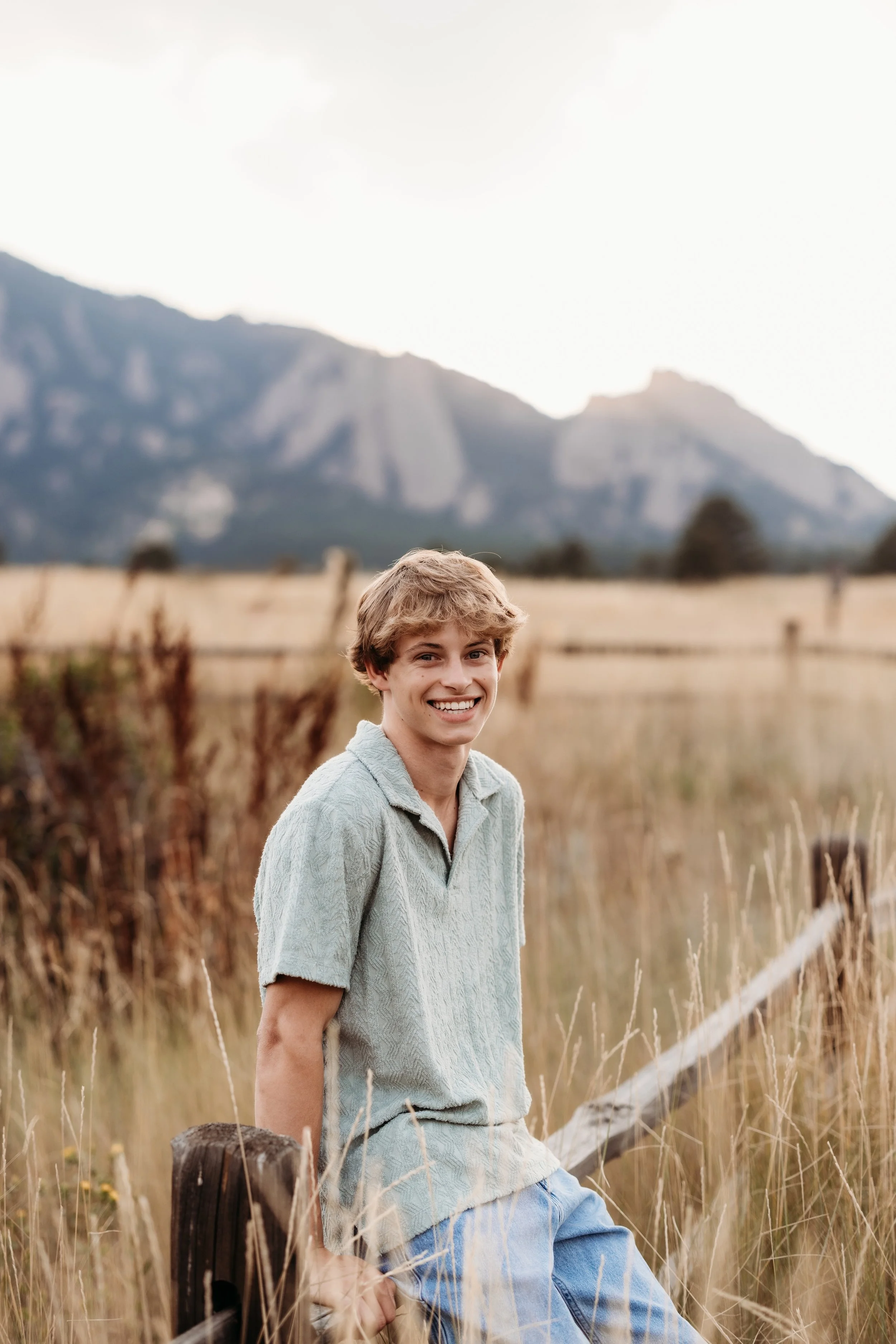 Boy smiling at the camera in a field.