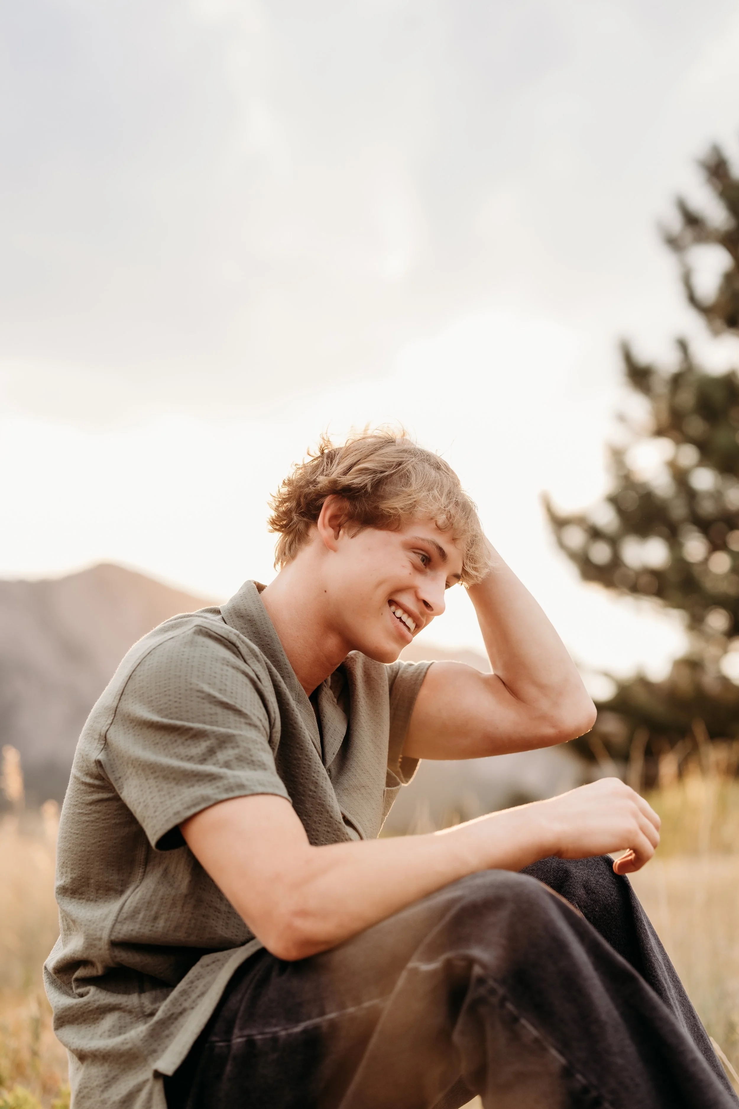 Teenage boy laughing at sunset.