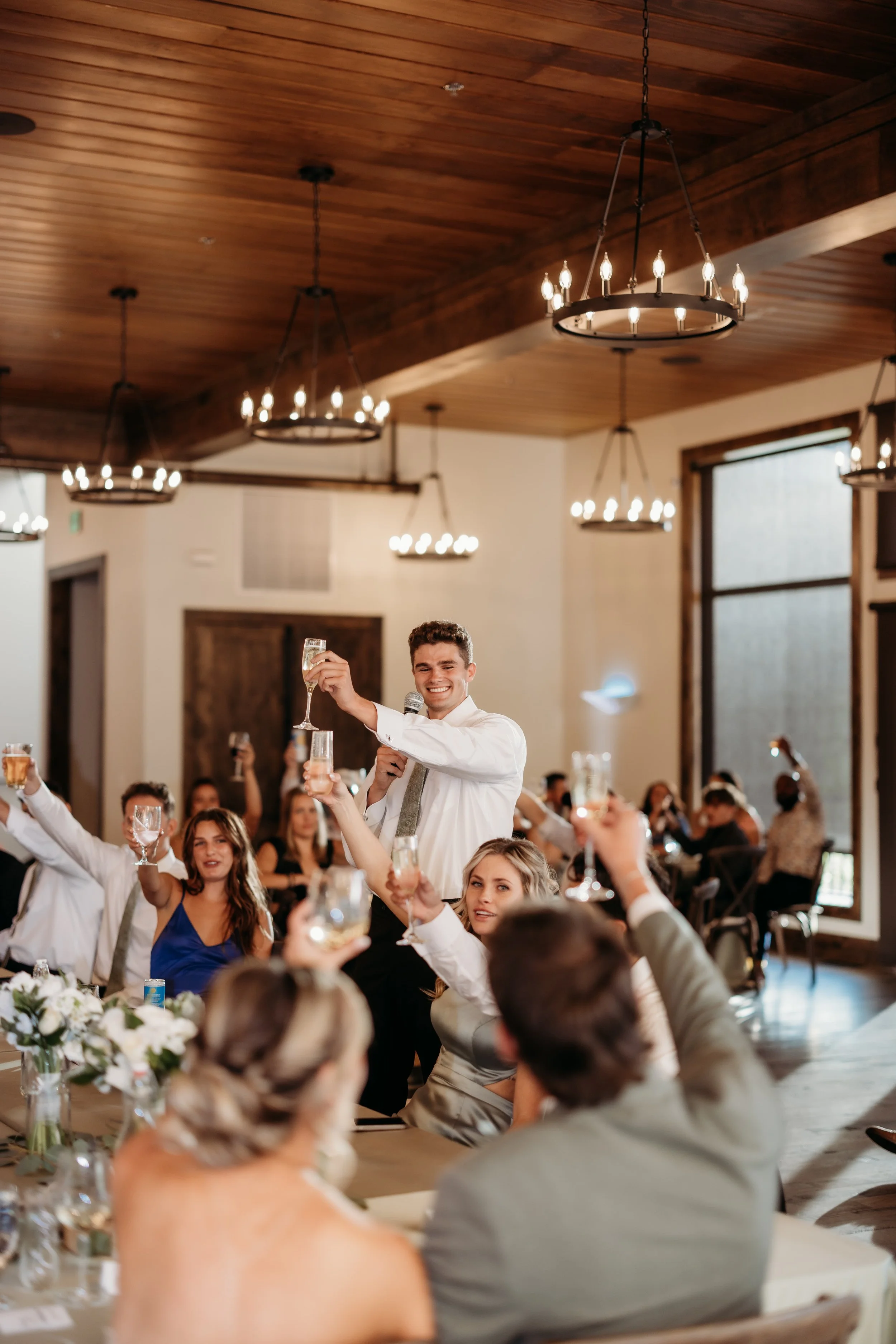 Groomsman giving a toast at a wedding reception.