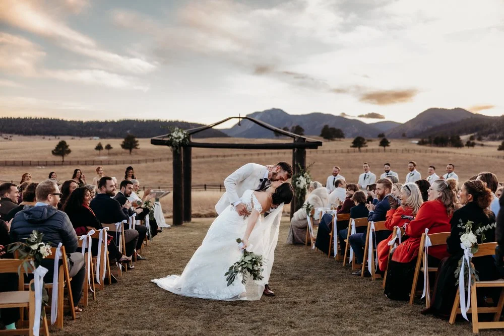 A bride and groom having their first kiss at Spruce Mountain Ranch.