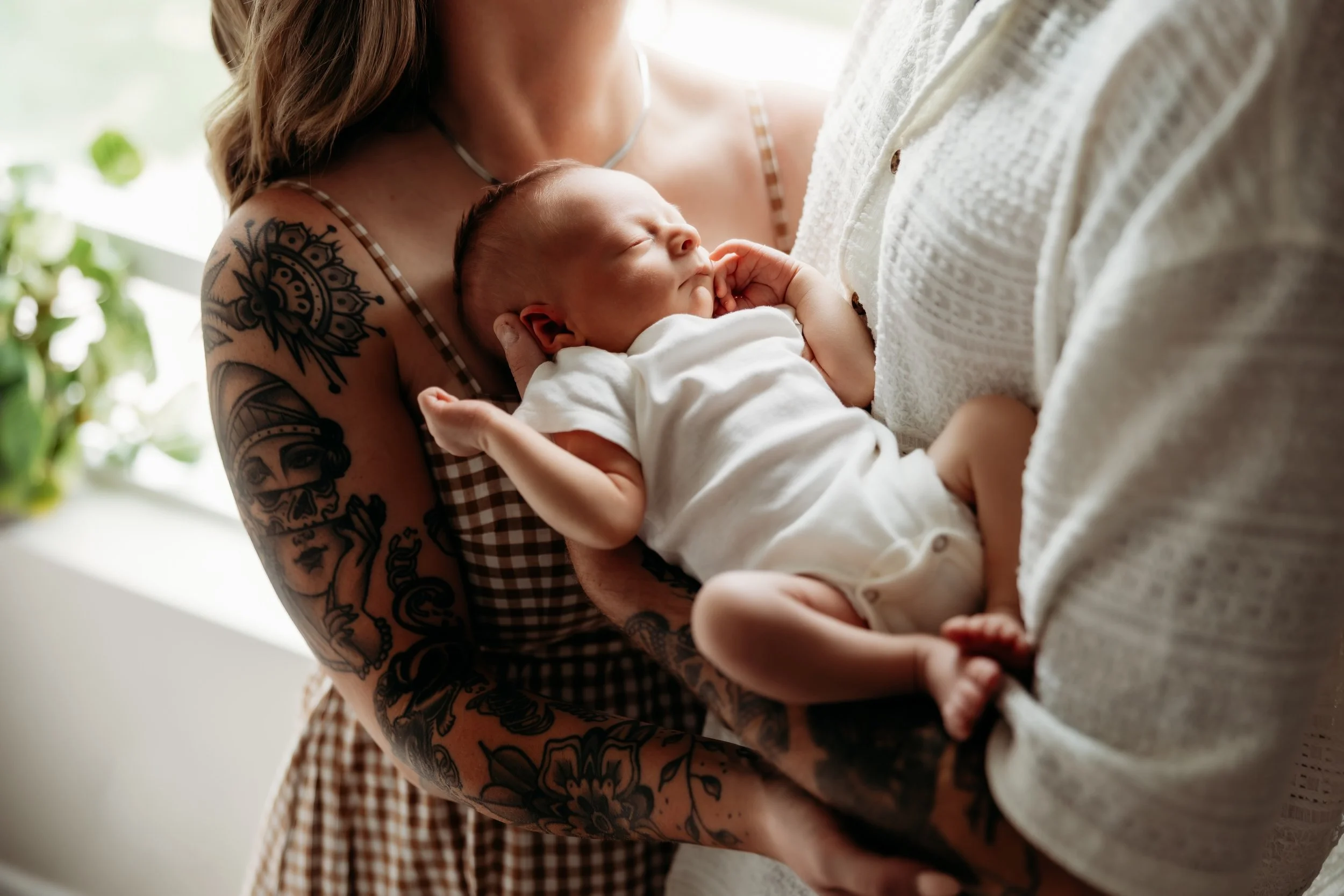 Two parents embracing their newborn.