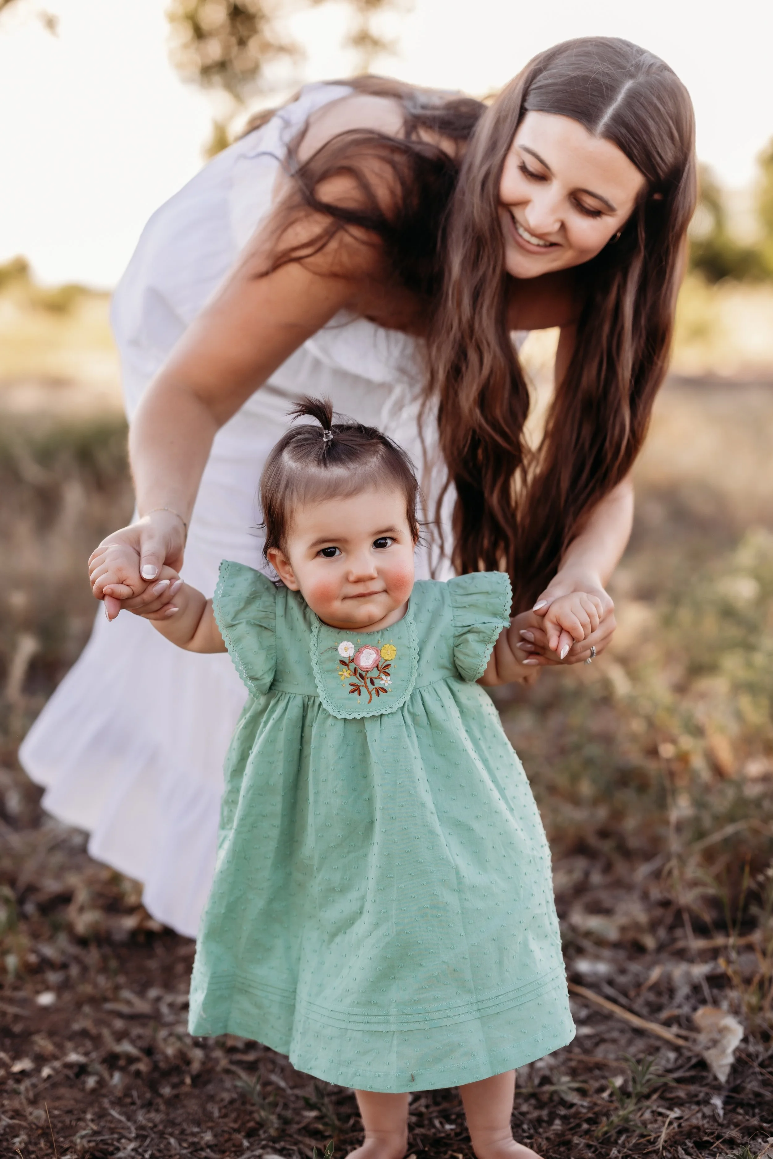 Mom smiling and walking with her toddler in Thornton, Colorado.
