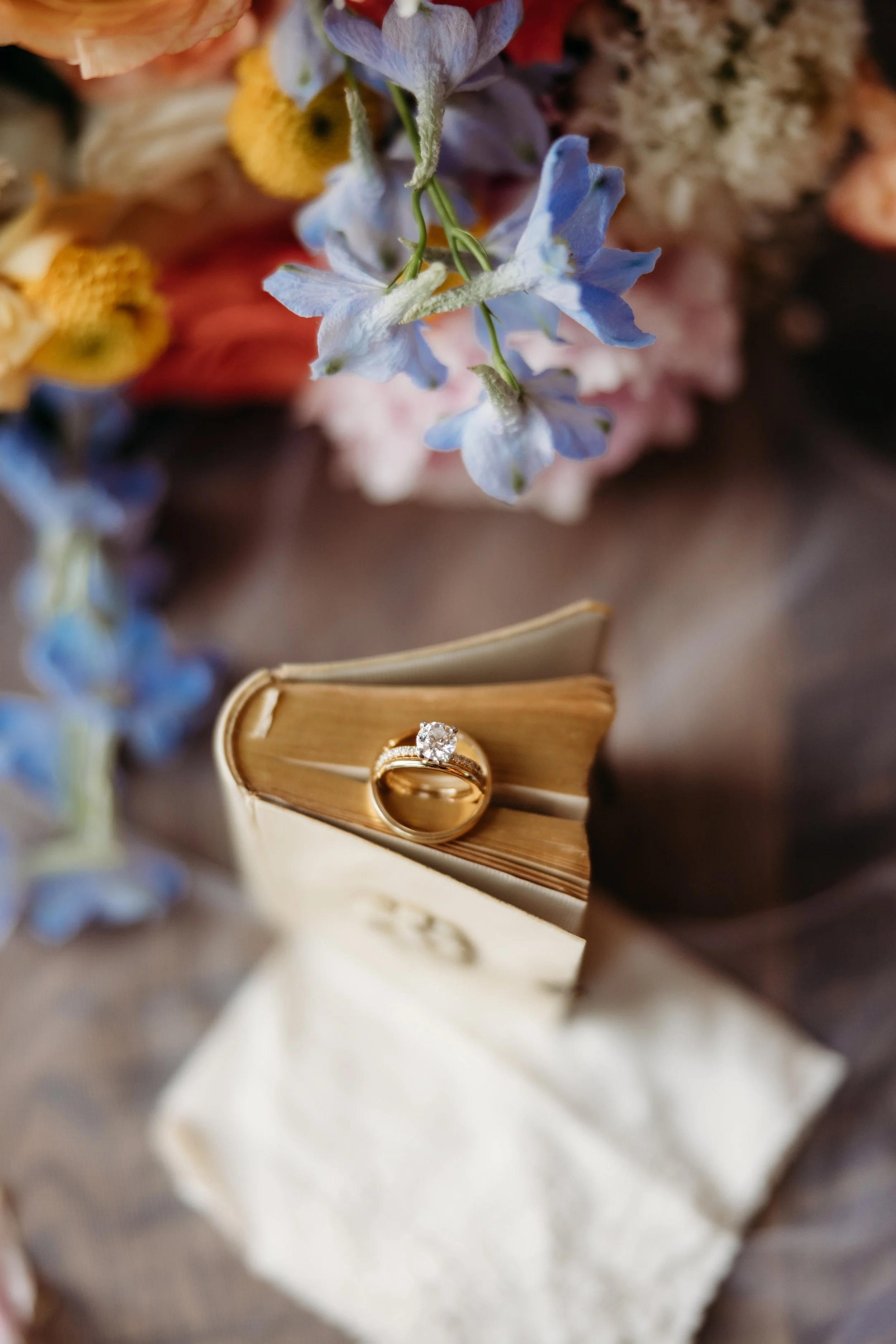 A bride's wedding ring laying on top of a book.