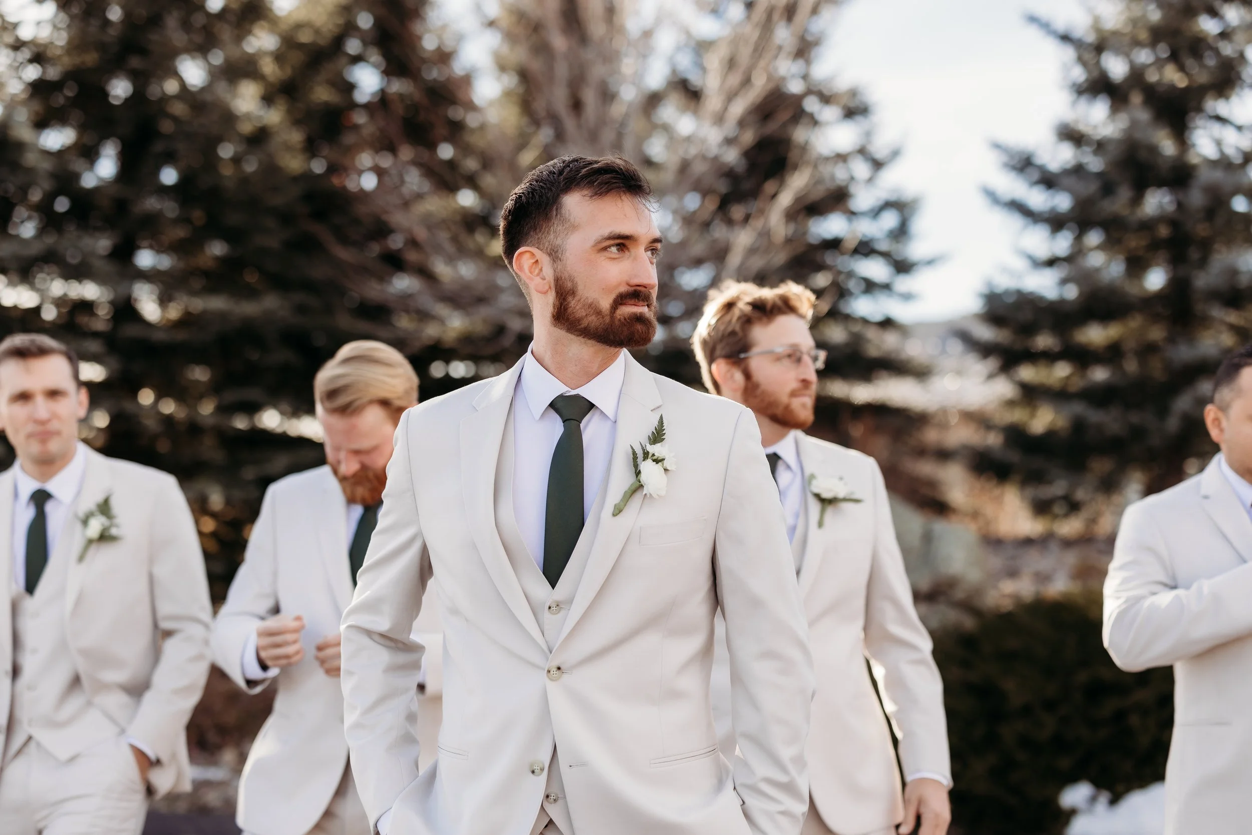 Groom and his groomsmen walking through a forest at Spruce Mountain.