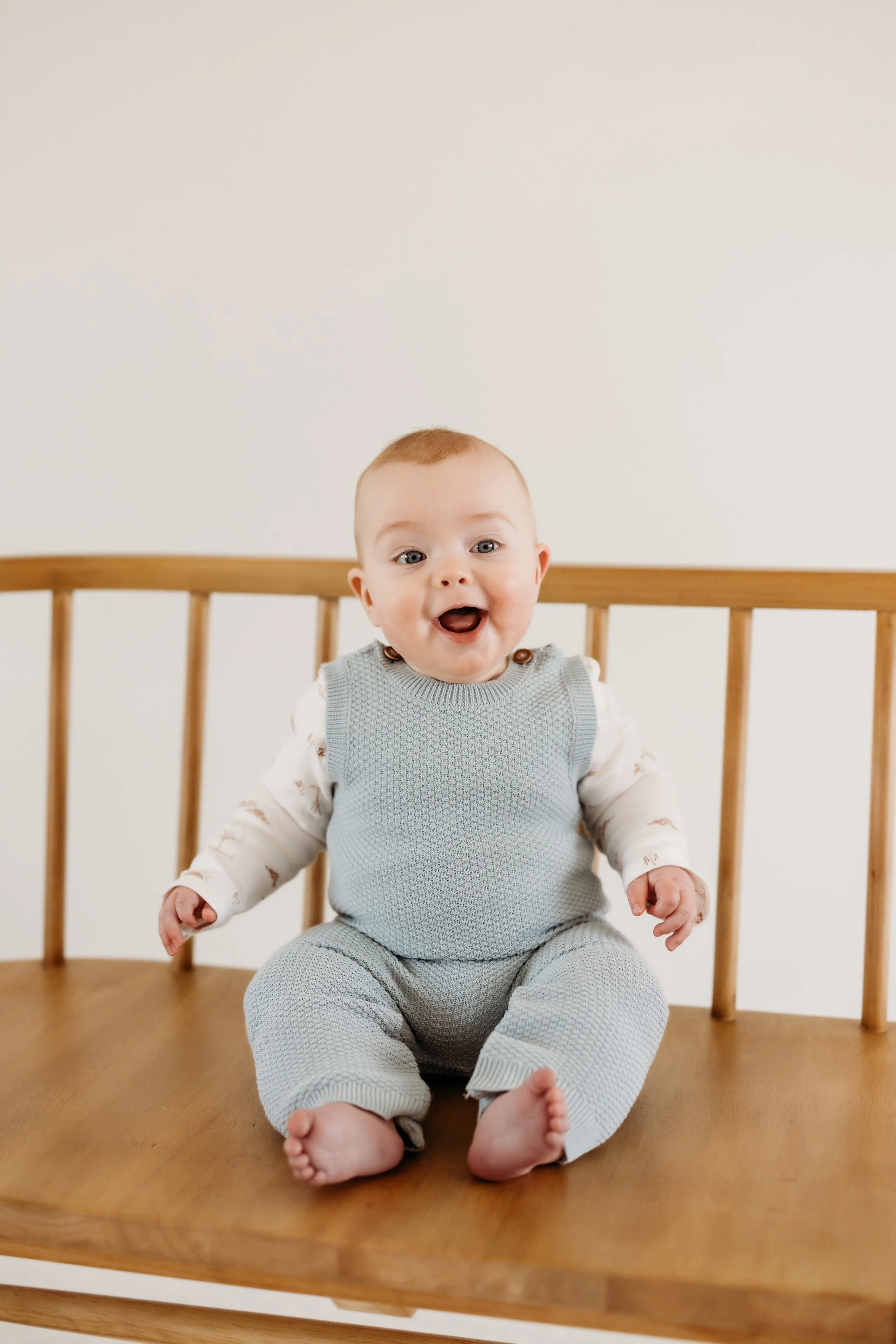 Smiling baby on a bench at SugarHill Studio in Longmont, Colorado.