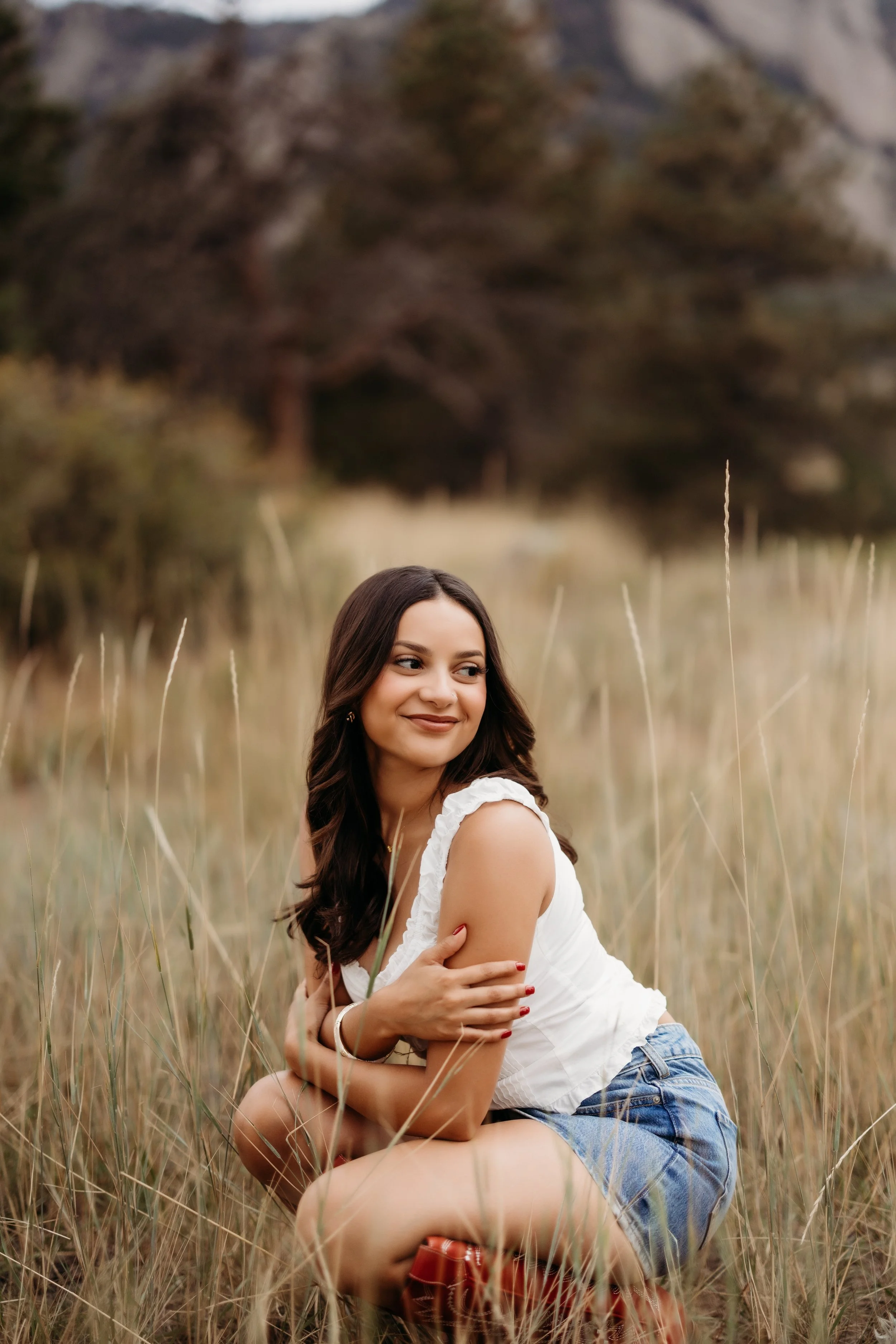 Teenage girl sitting in a field.