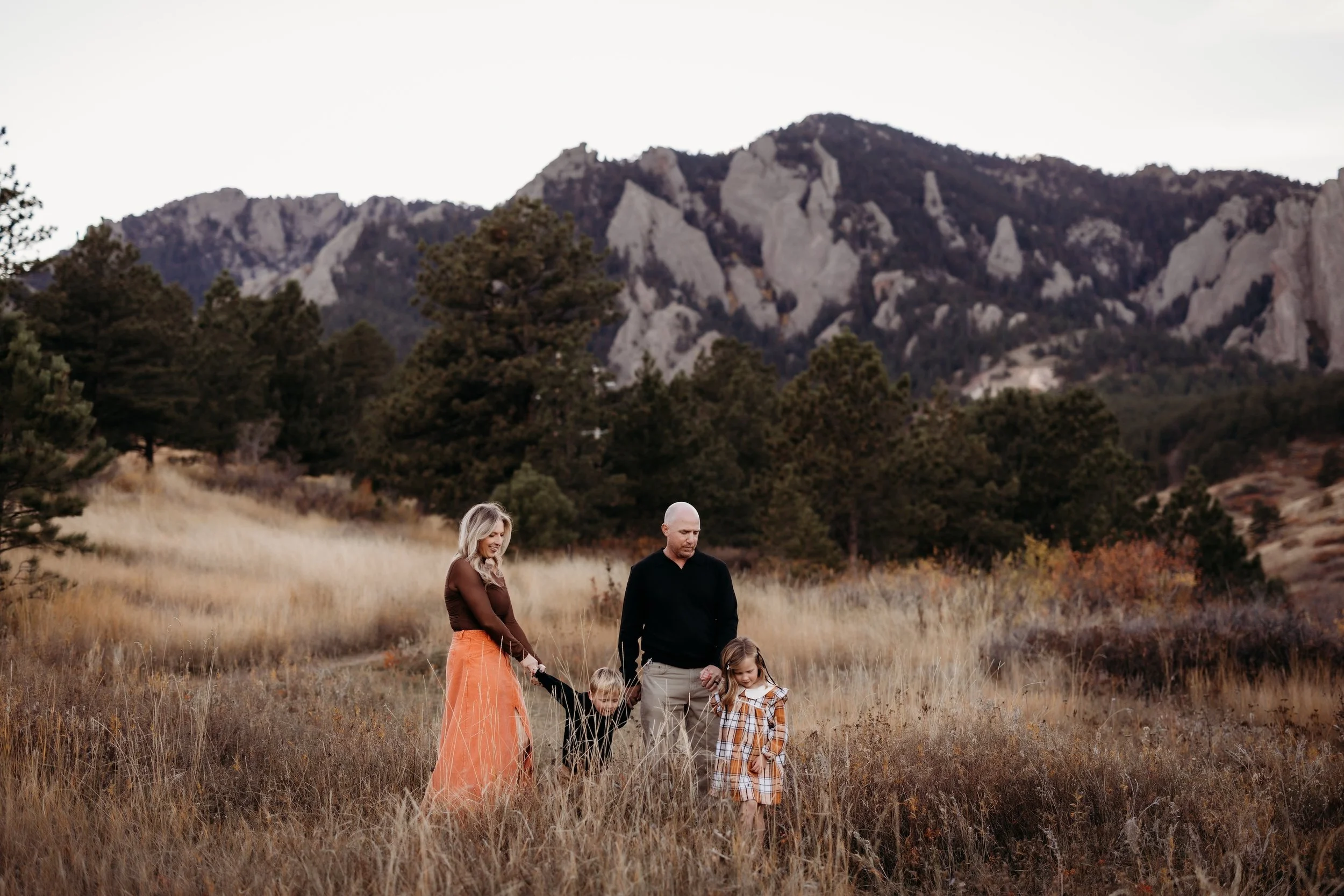 Family of four walking through Chautauqua Park in Boulder, Colorado.