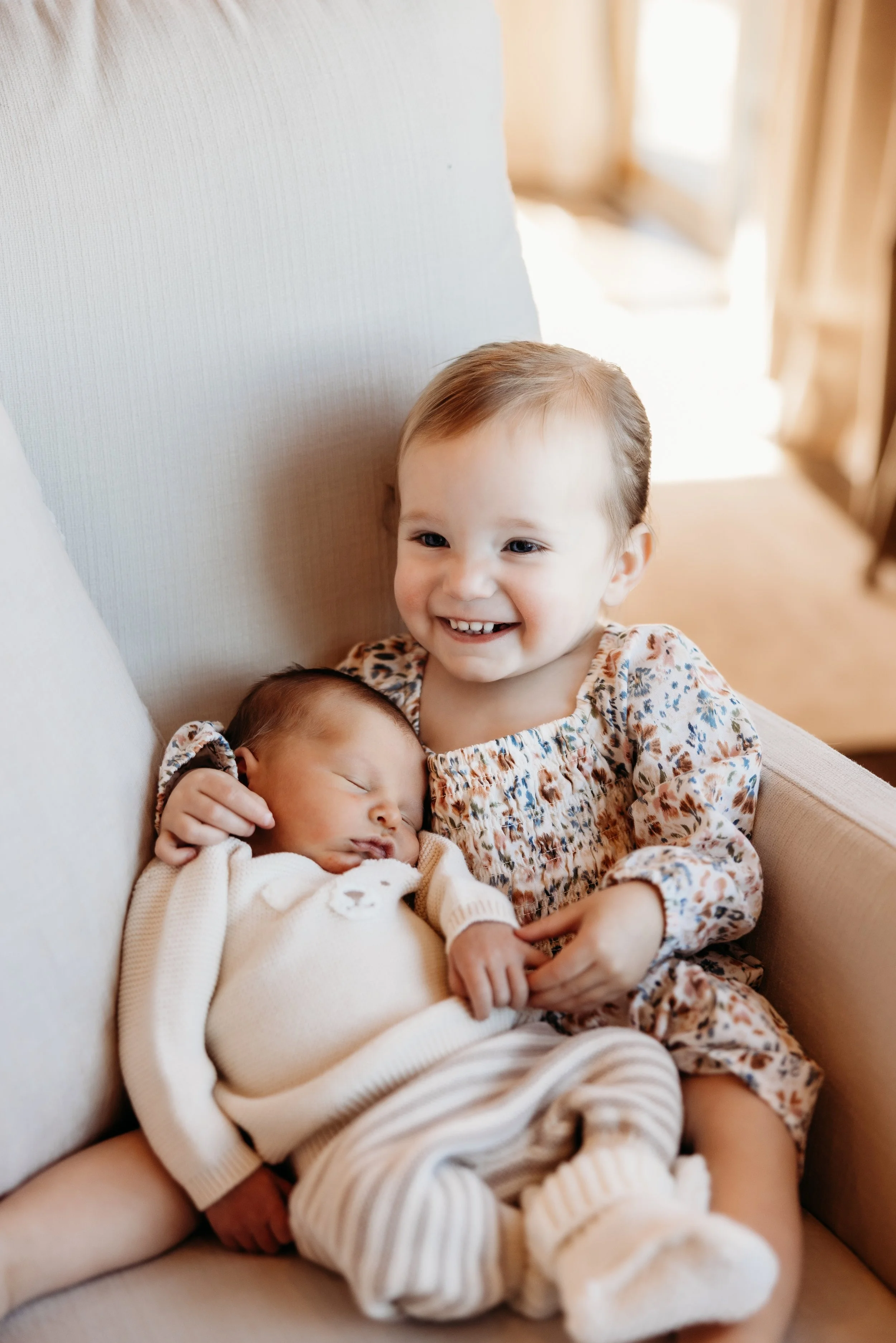Older sister holding her newborn sibling.
