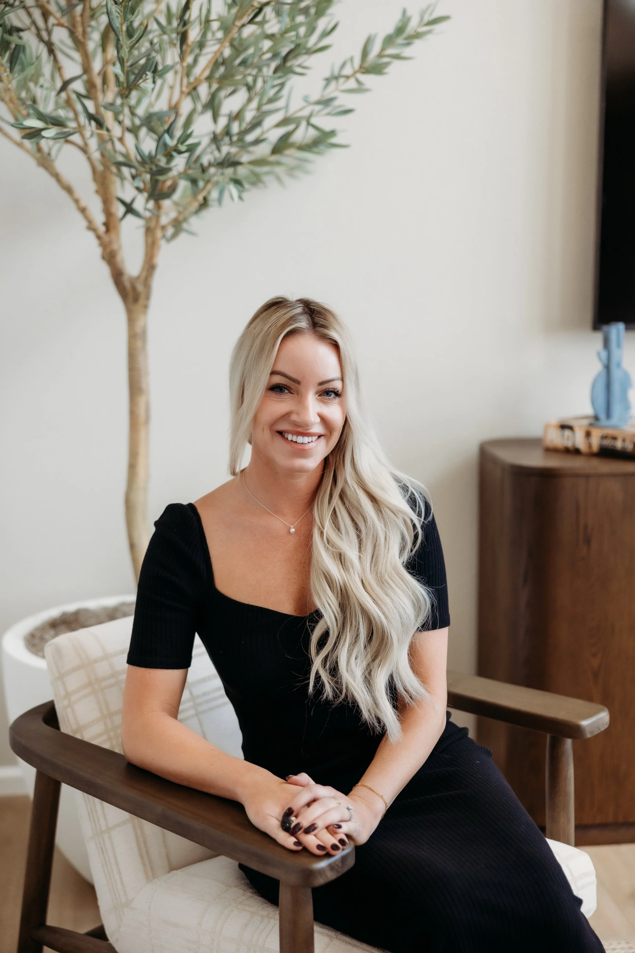 Woman sitting on a chair and smiling.