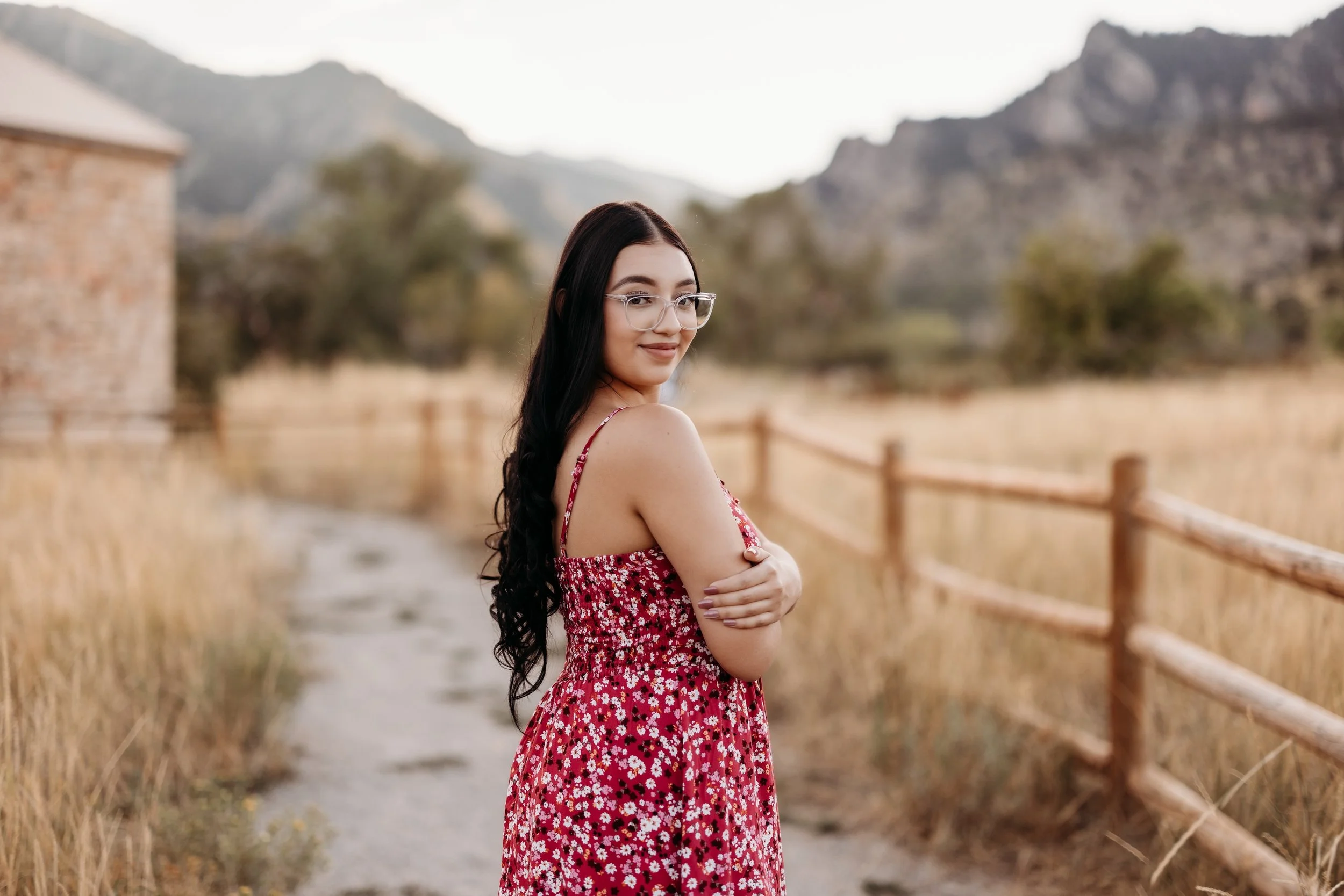 Girl in a red dress looking over her shoulder and smiling.