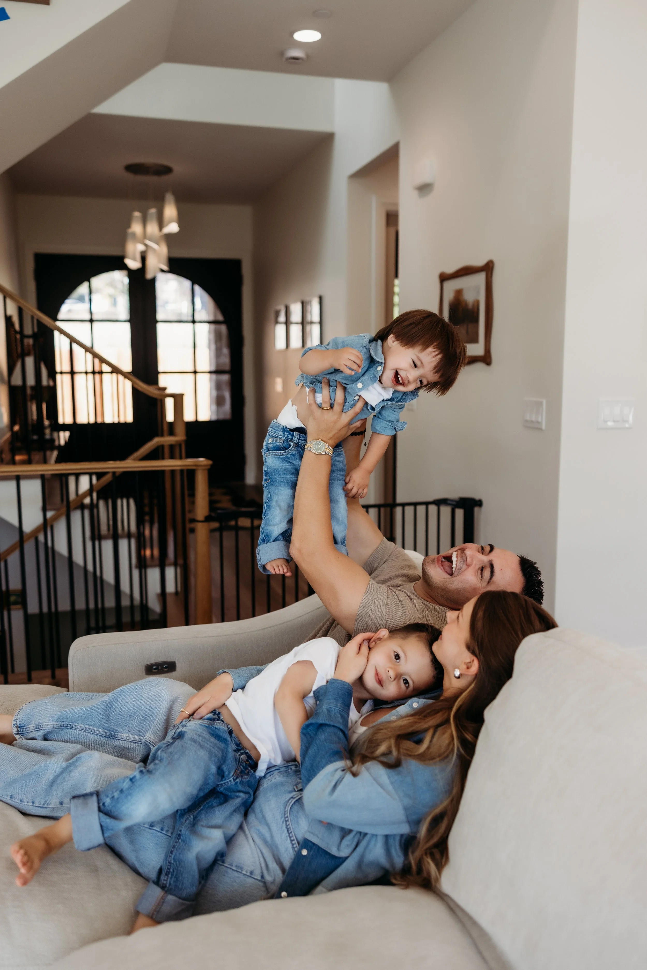 Parents laughing and playing with their two young children.