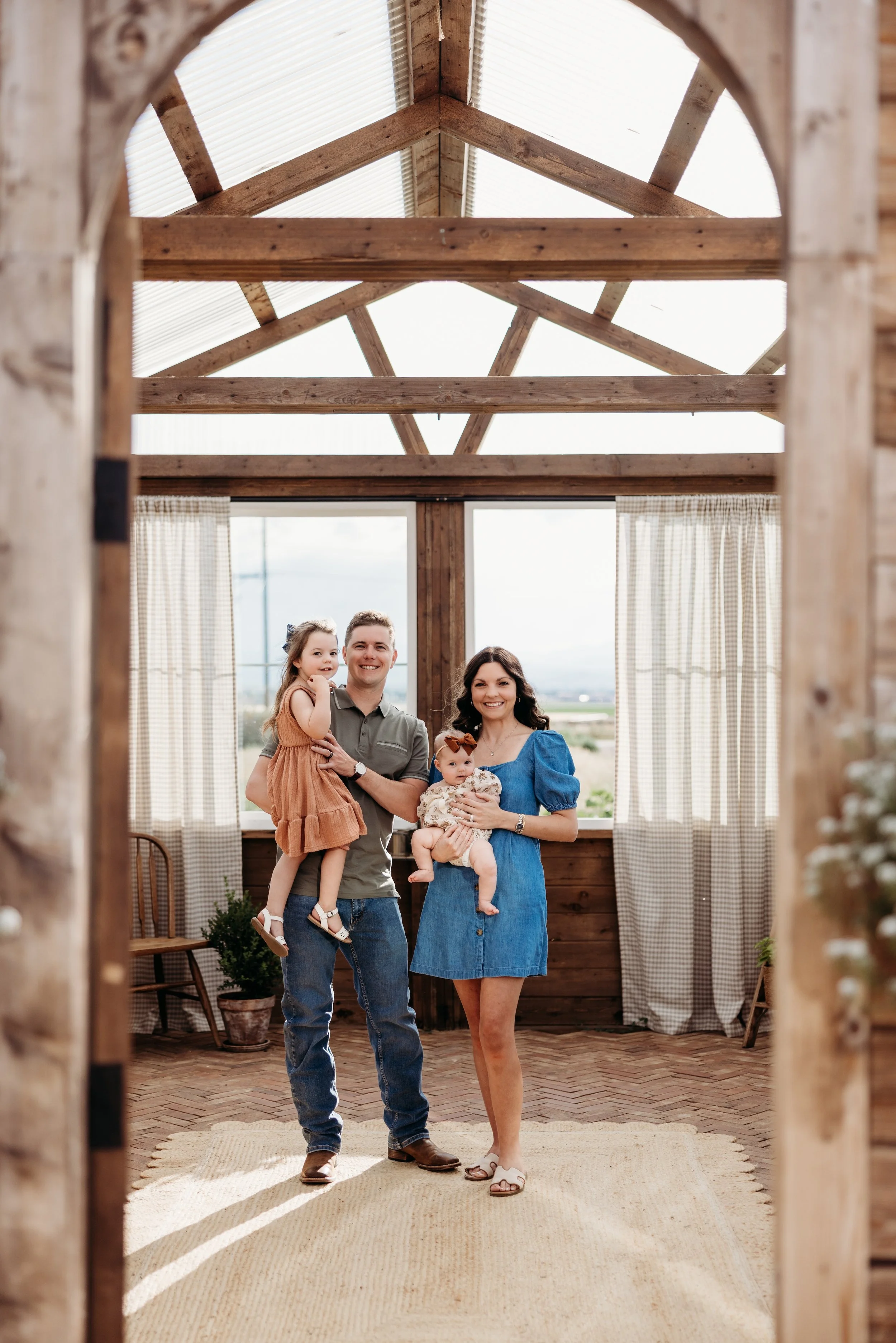 Family of four posing together inside a greenhouse in Longmont, Colorado.