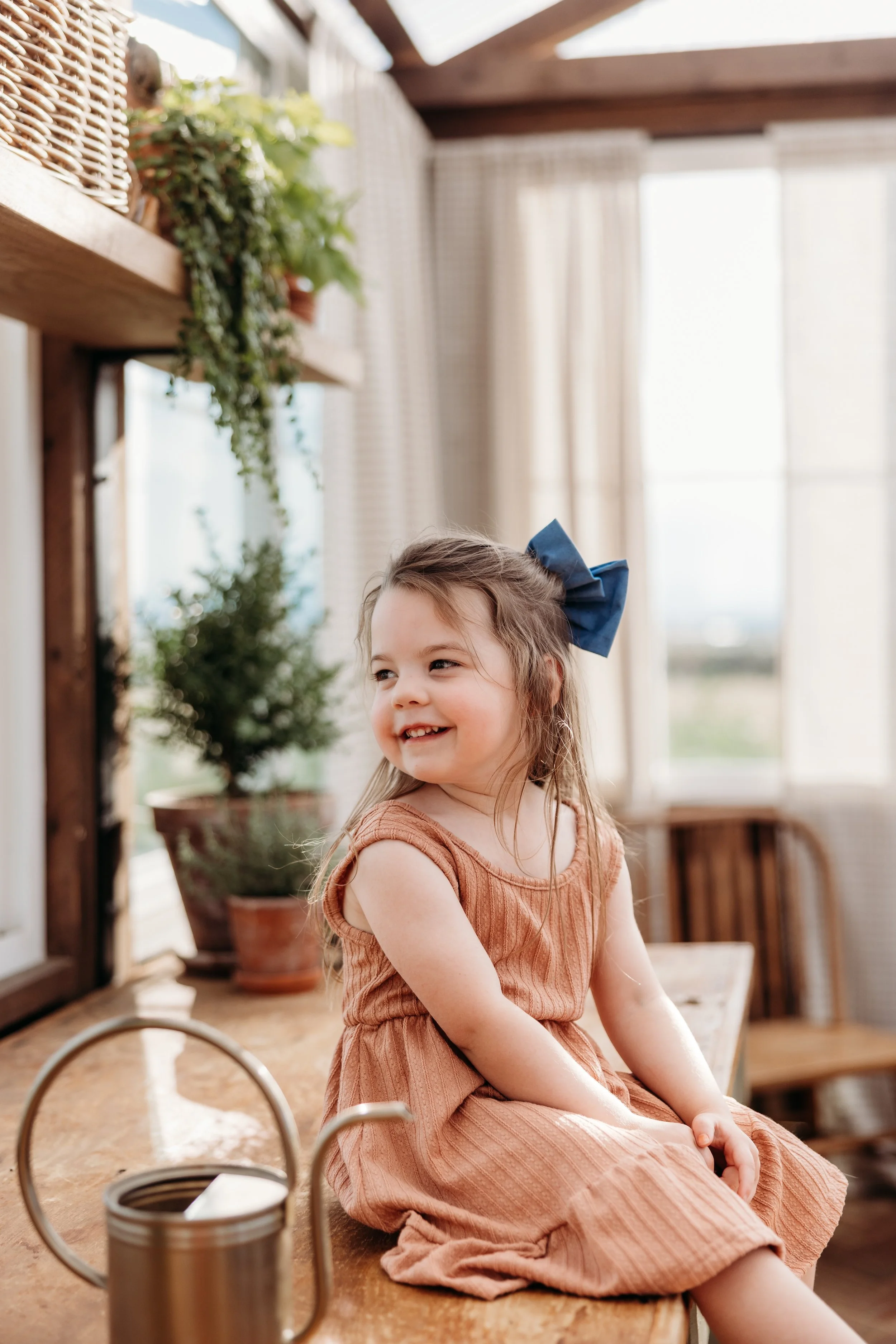 Toddler girl smiling and sitting on a countertop.