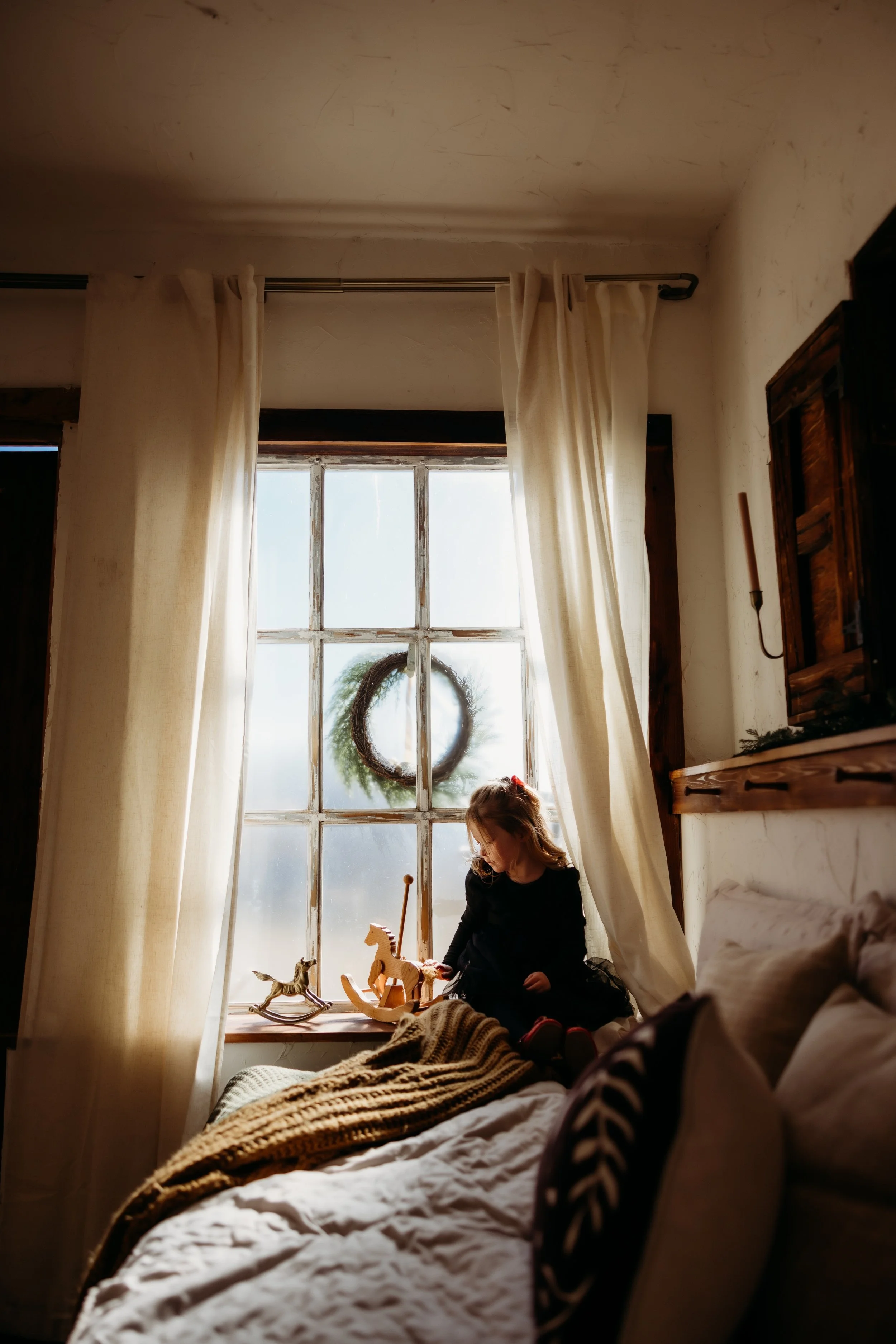 Young girl sitting by a window.