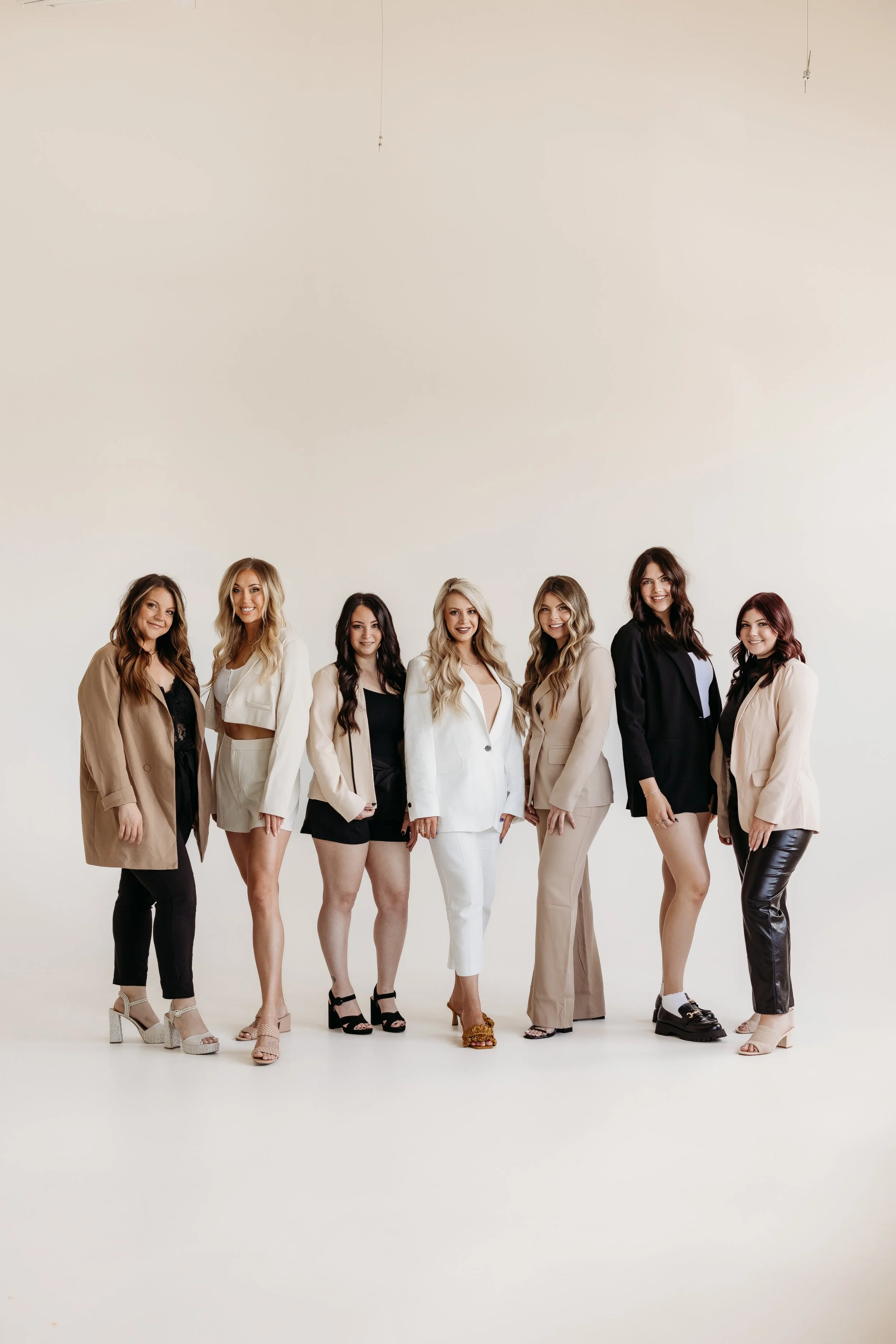 Seven women posing together during a branding photography session.