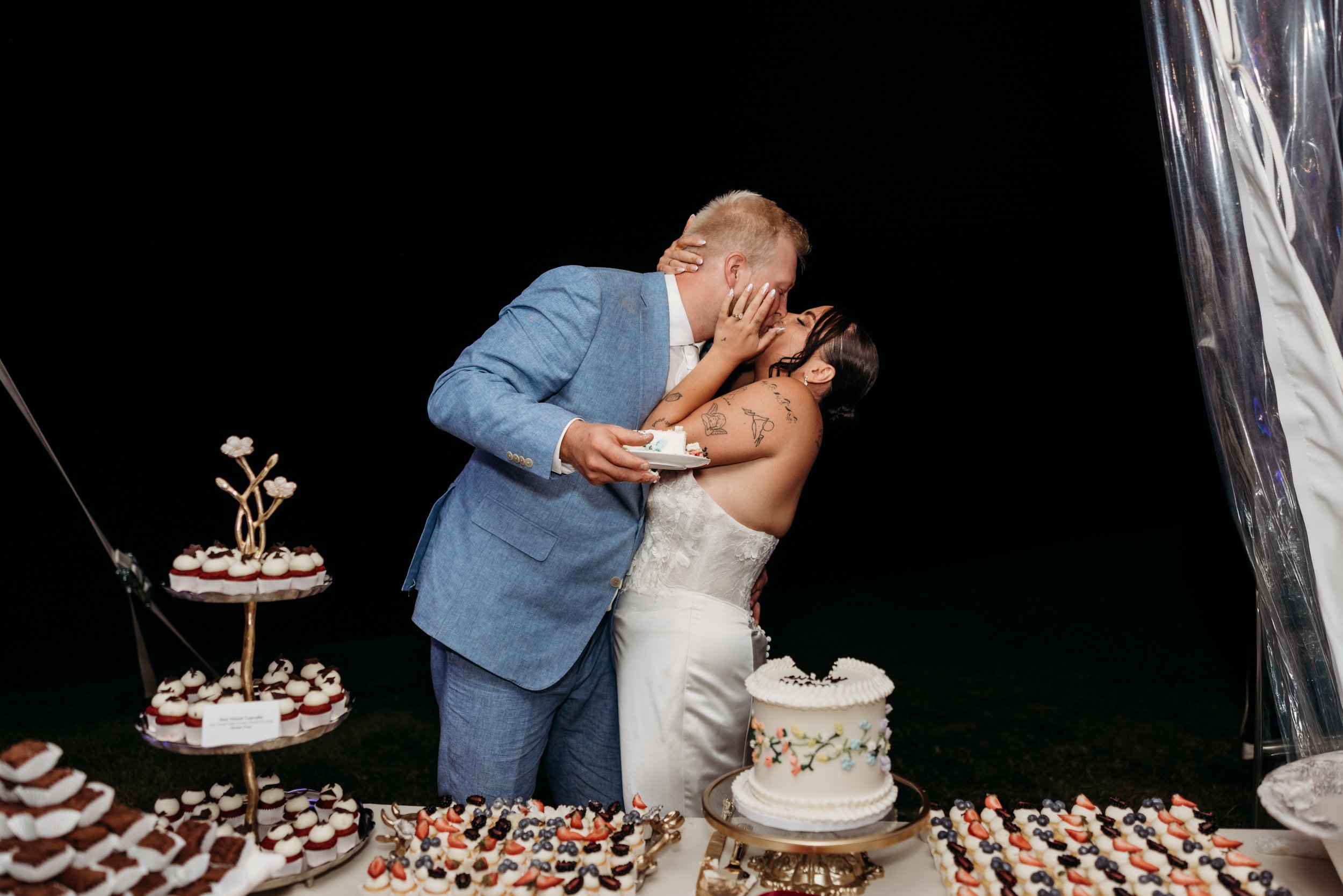 Bride and groom kissing after cutting their wedding cake.