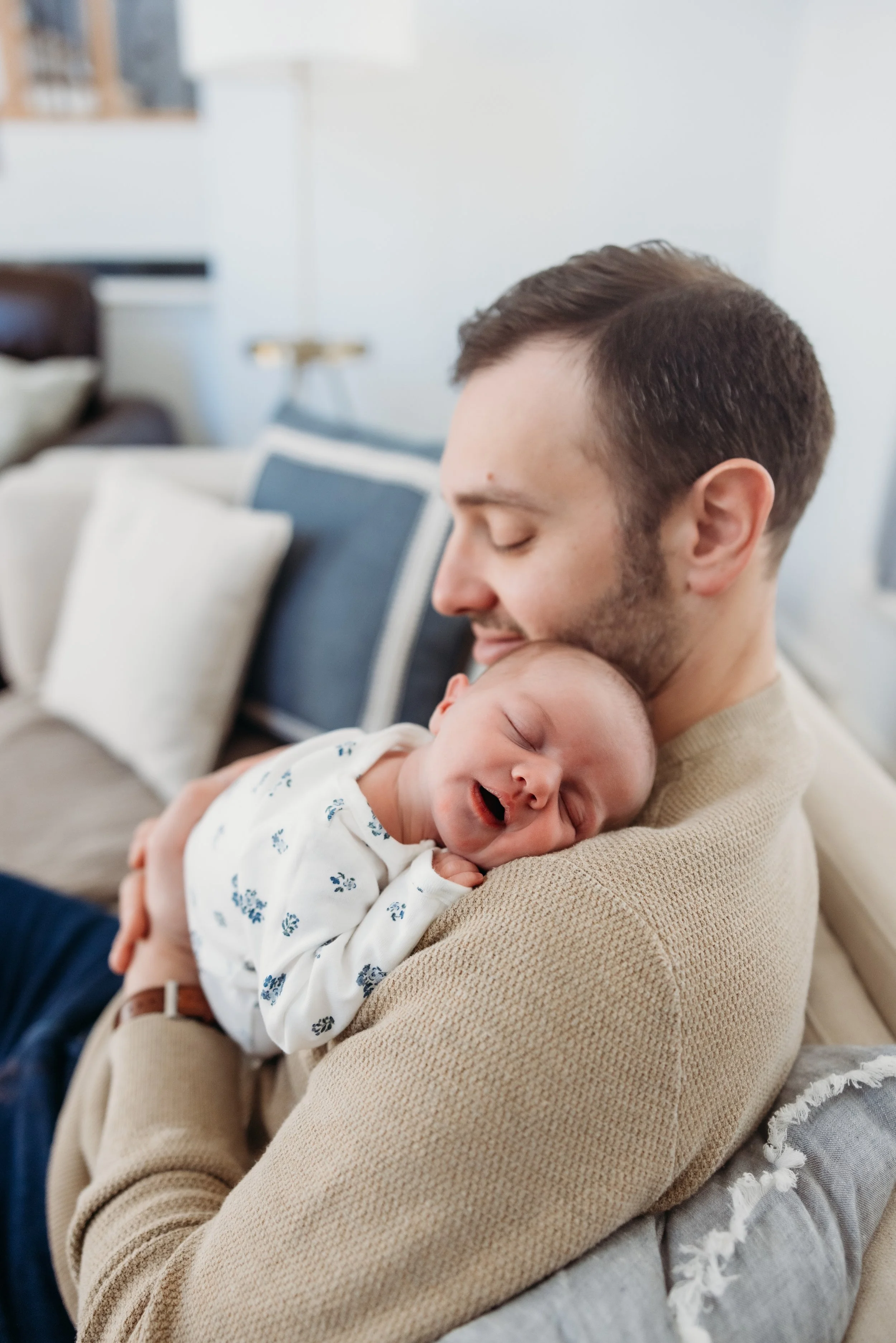 Dad holding a sleeping newborn.