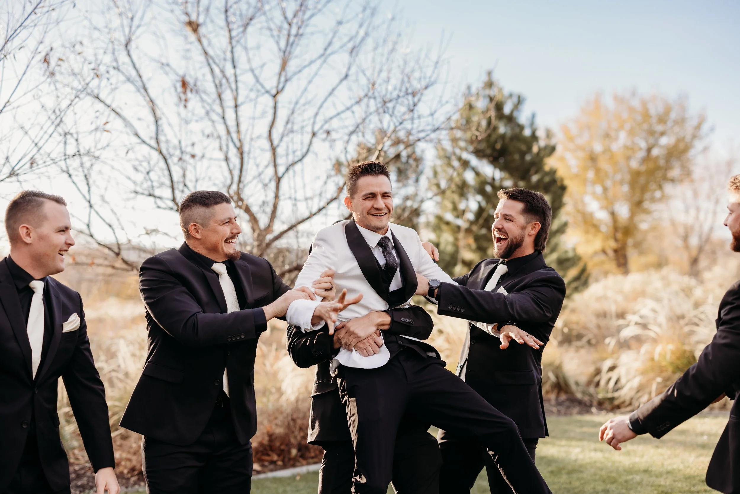 Groomsmen picking up groom.