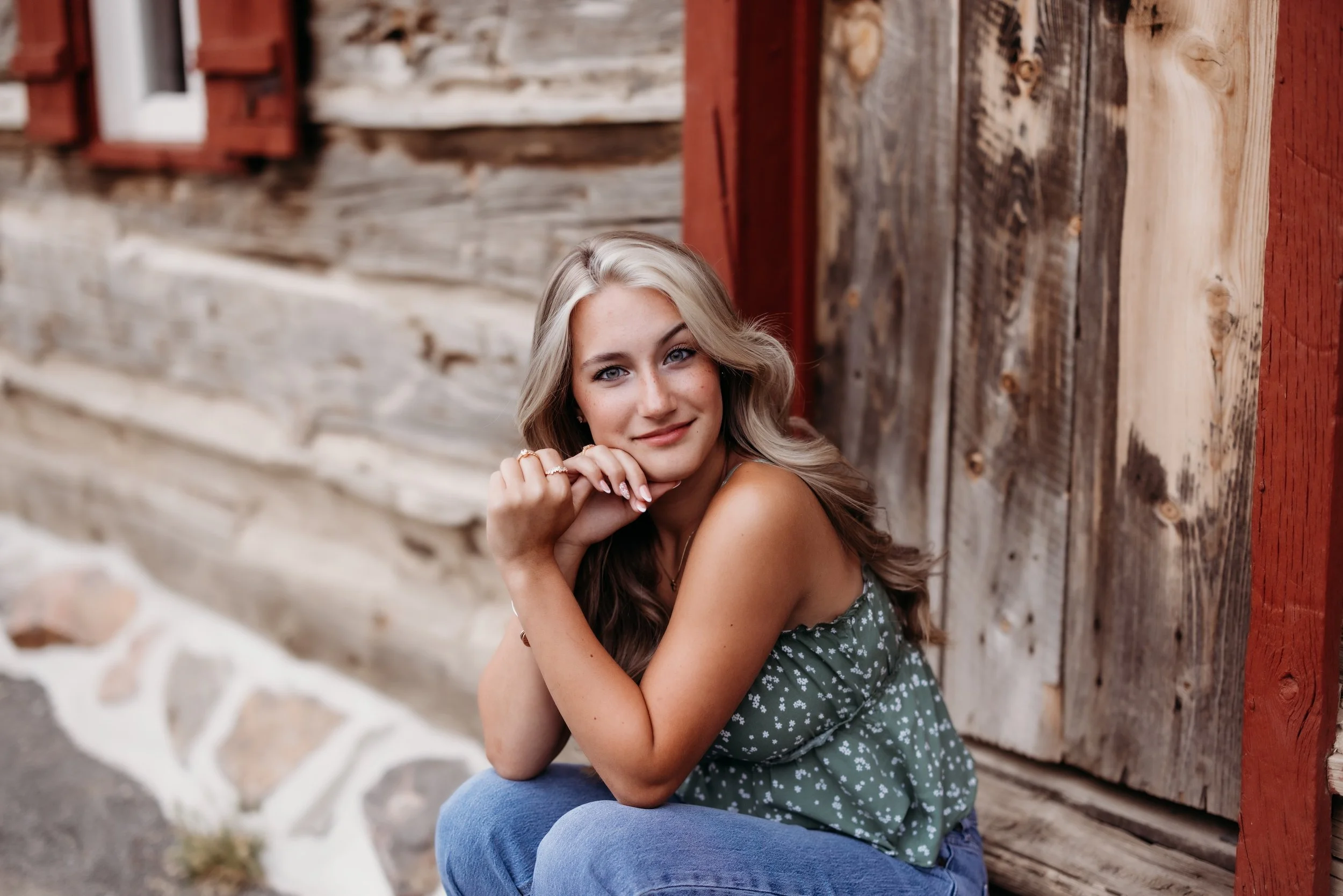 Senior girl sitting on a wooden doorstep.