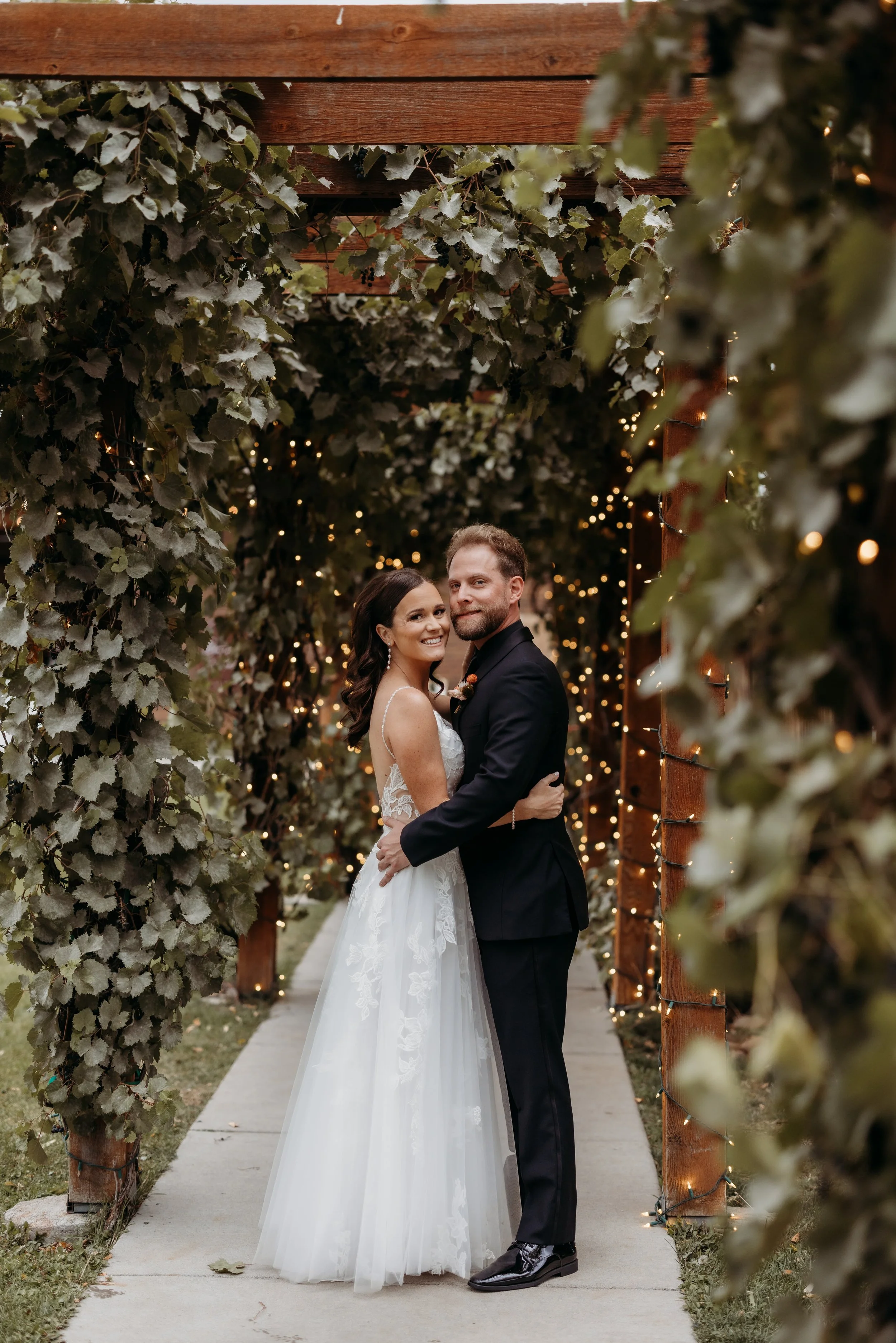 Bride and groom embracing at their wedding ceremony at the Balistreri Vineyards.