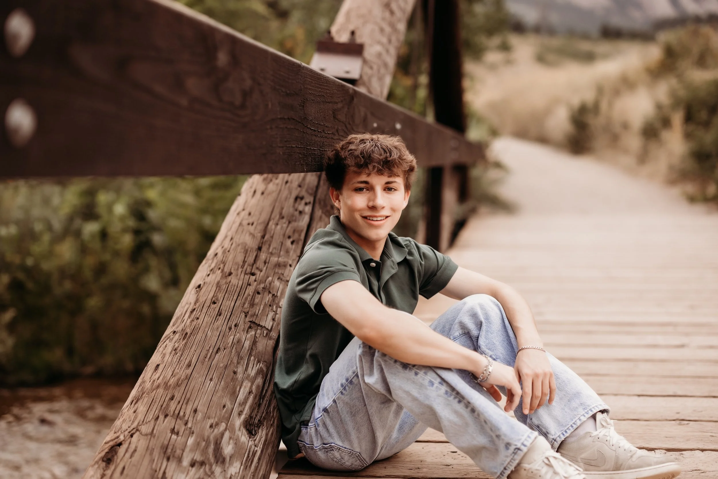Senior boy sitting on a bridge in Denver, Colorado.