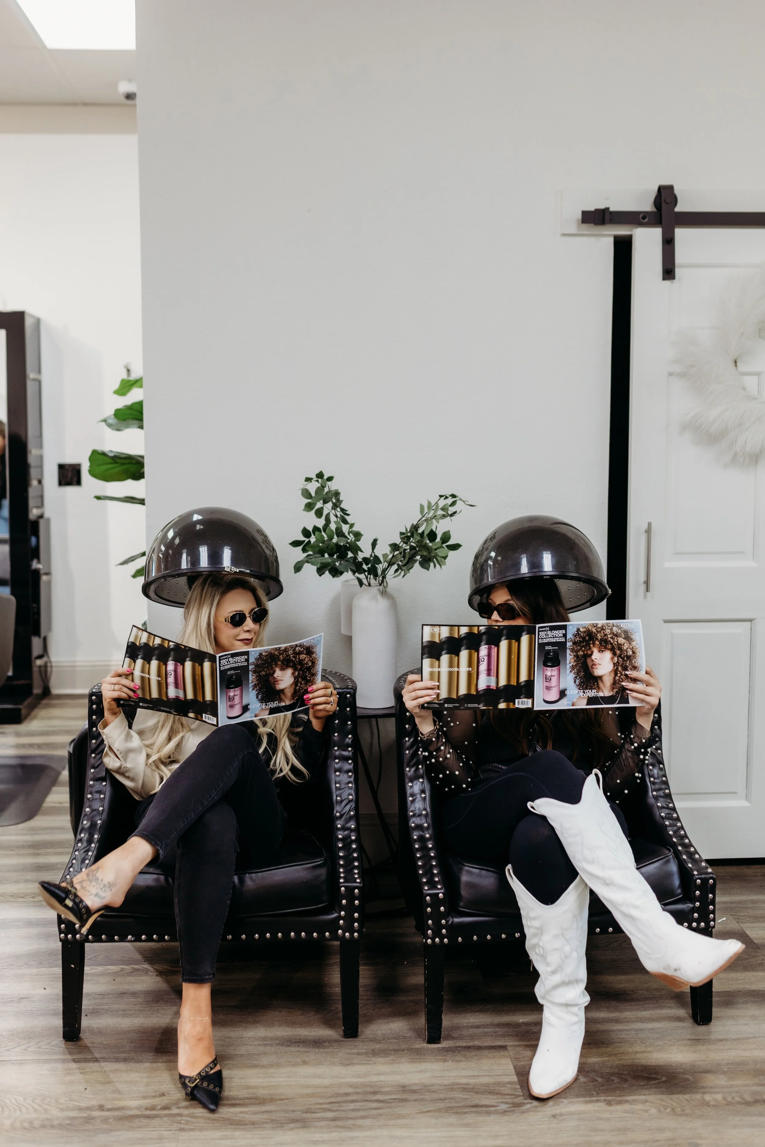 Two women sitting under hair dryers at Bleach'd Salon in Westminster, Colorado.