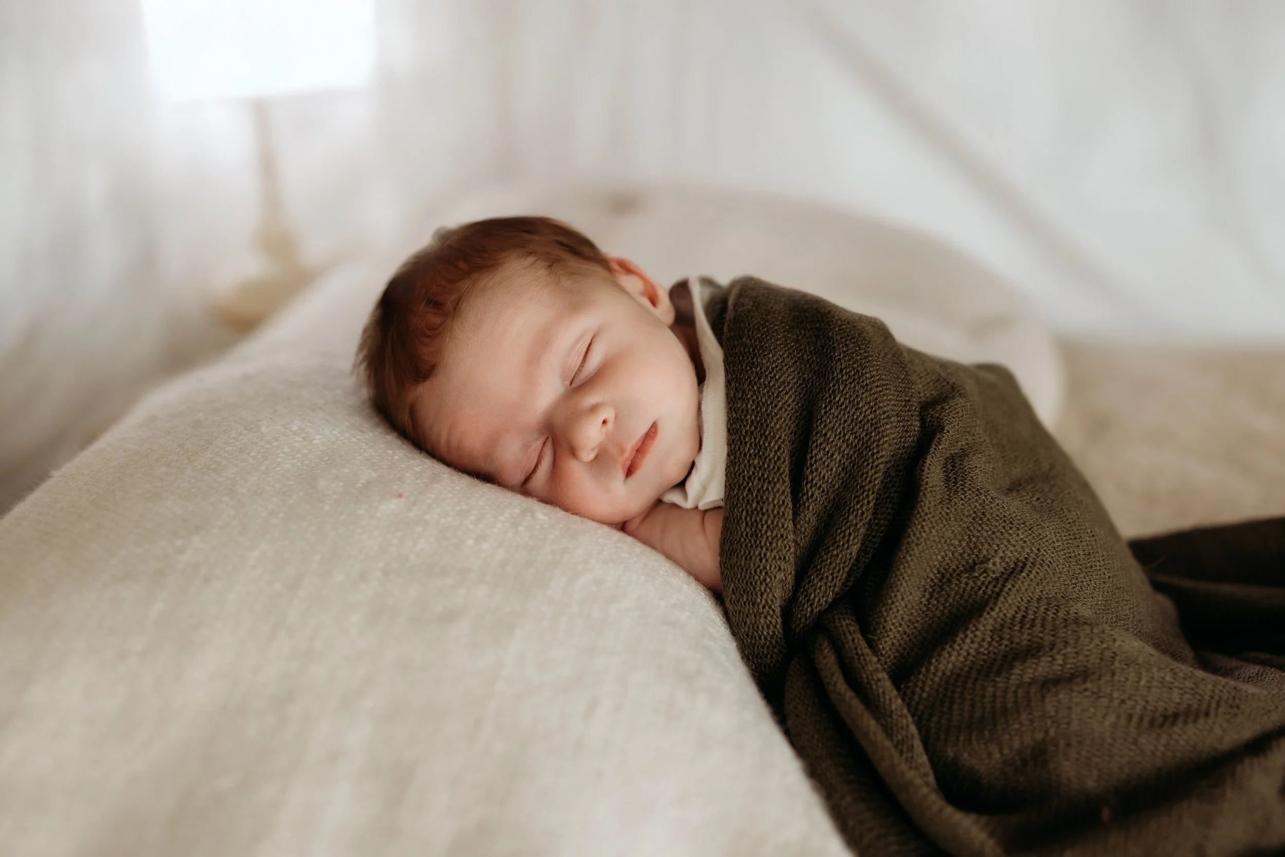 Sleeping newborn wrapped in a blanket.