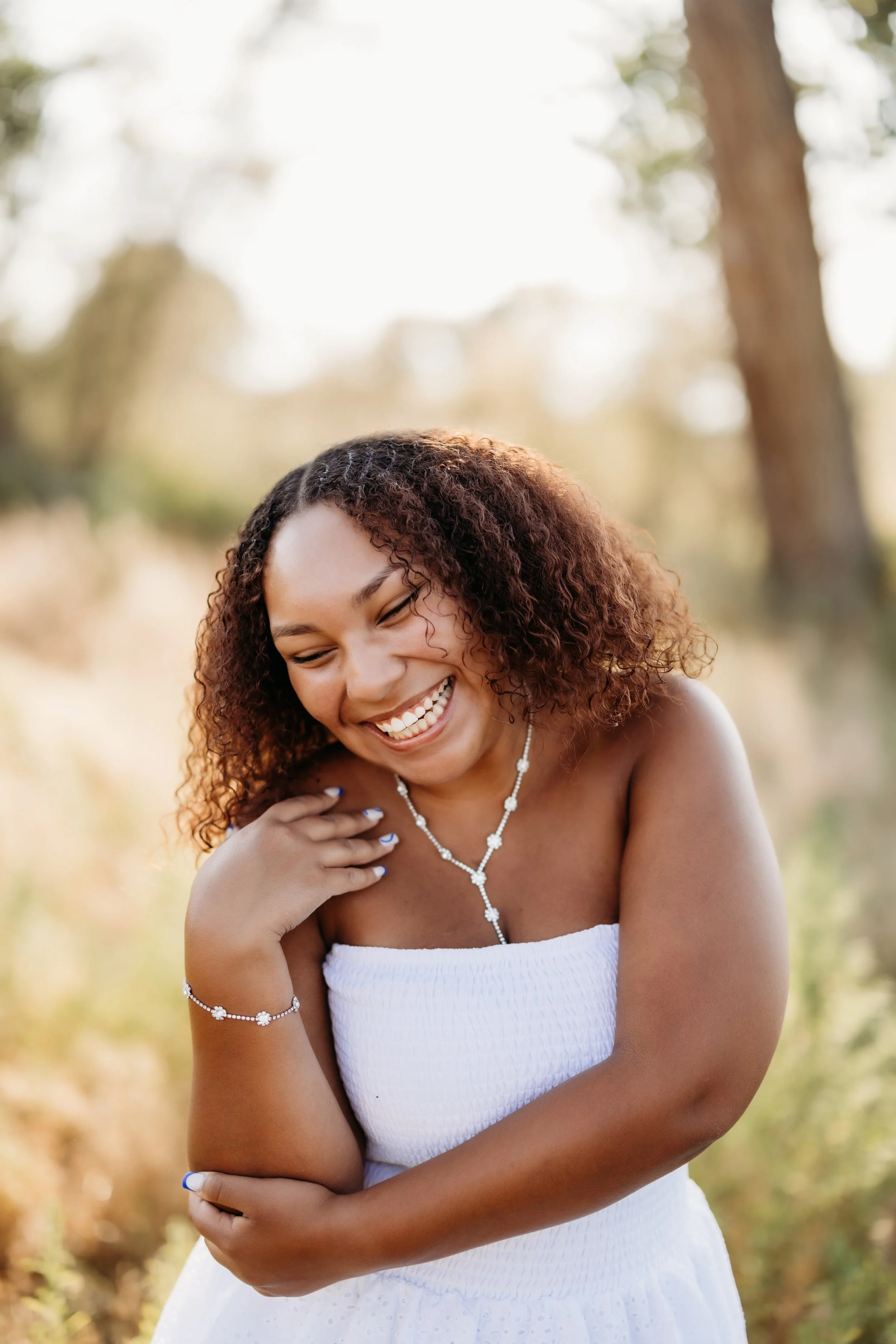 Senior girl laughing in a field in Boulder, Colorado.