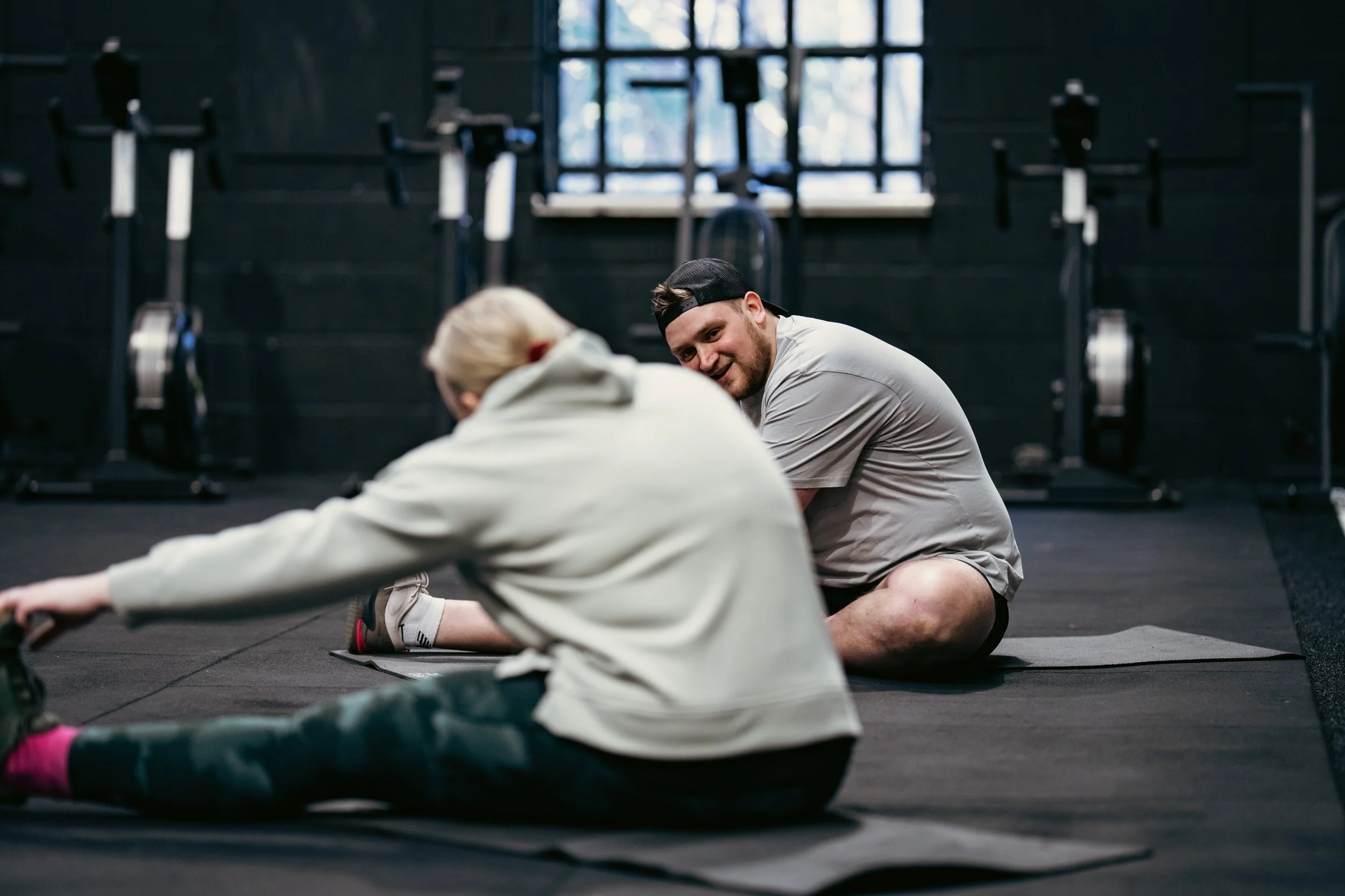 Client receiving coaching tips  to improve movement and reduce discomfort in Winchester gym.