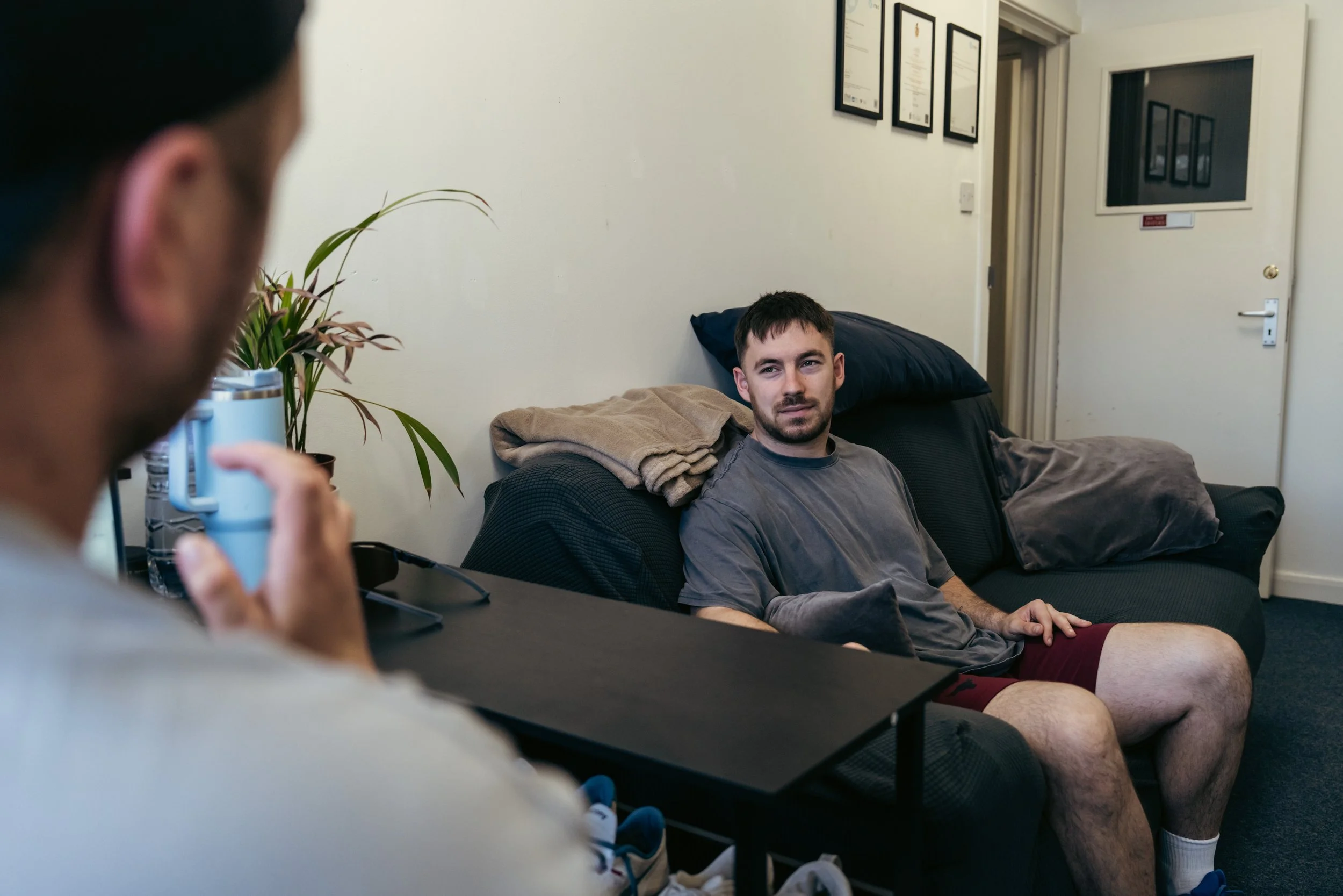 Sports therapist discussing symptoms, training history and rehabilitation goals with a client during an initial consultation at a sports therapy clinic in Winchester.
