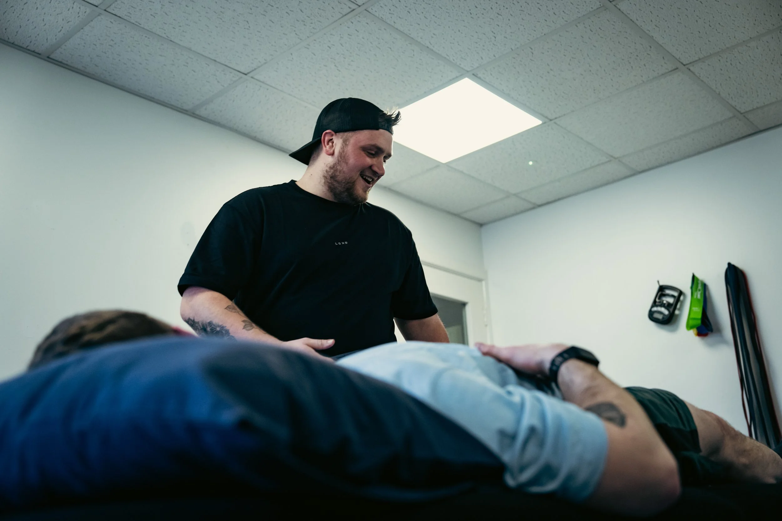 Sports therapist carrying out hands on treatment with a client lying on a treatment table at Training and Treatment sports therapy clinic in Winchester.