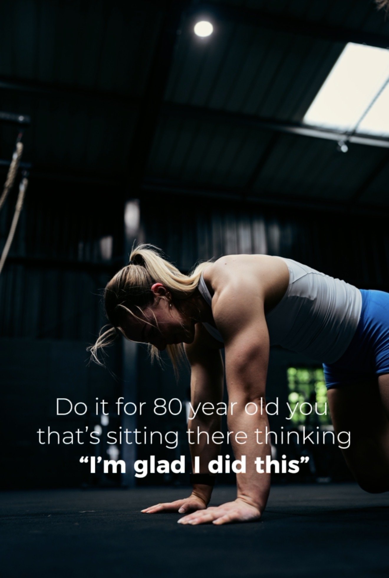 Female athlete completing a floor based mobility exercise in a CrossFit gym, highlighting how training can support health and independence later in life.