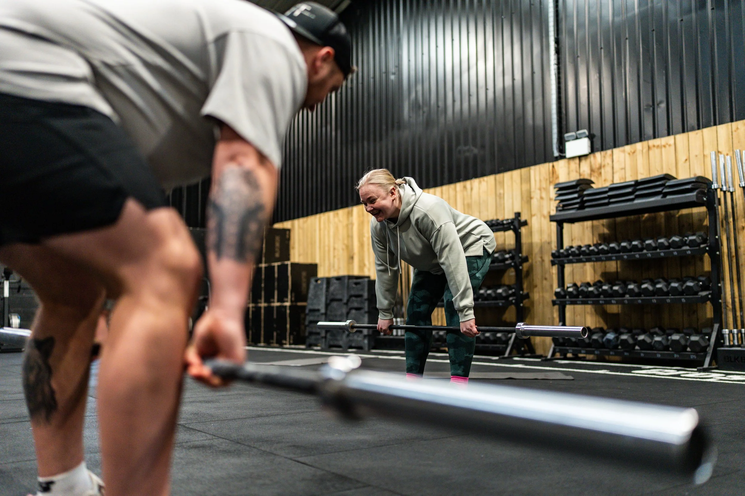 Sports therapist coaching a client through deadlift technique in the gym in Winchester.